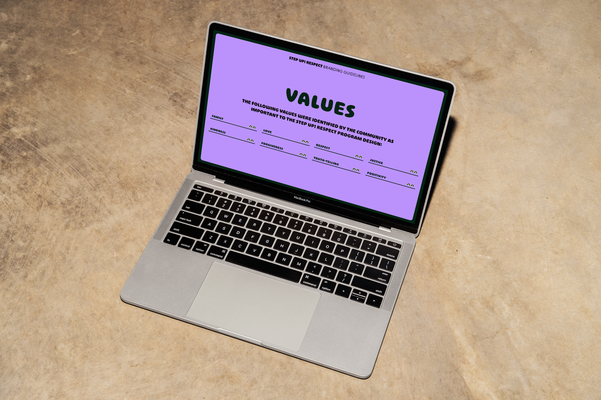 An open laptop with the Step Up! Respect branding guidelines open to the values page.