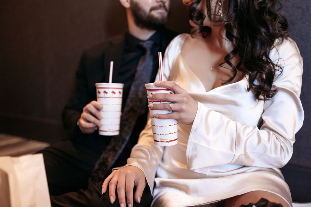 Stephanie and Gary eat In-N-Out burgers together in their Las Vegas hotel room