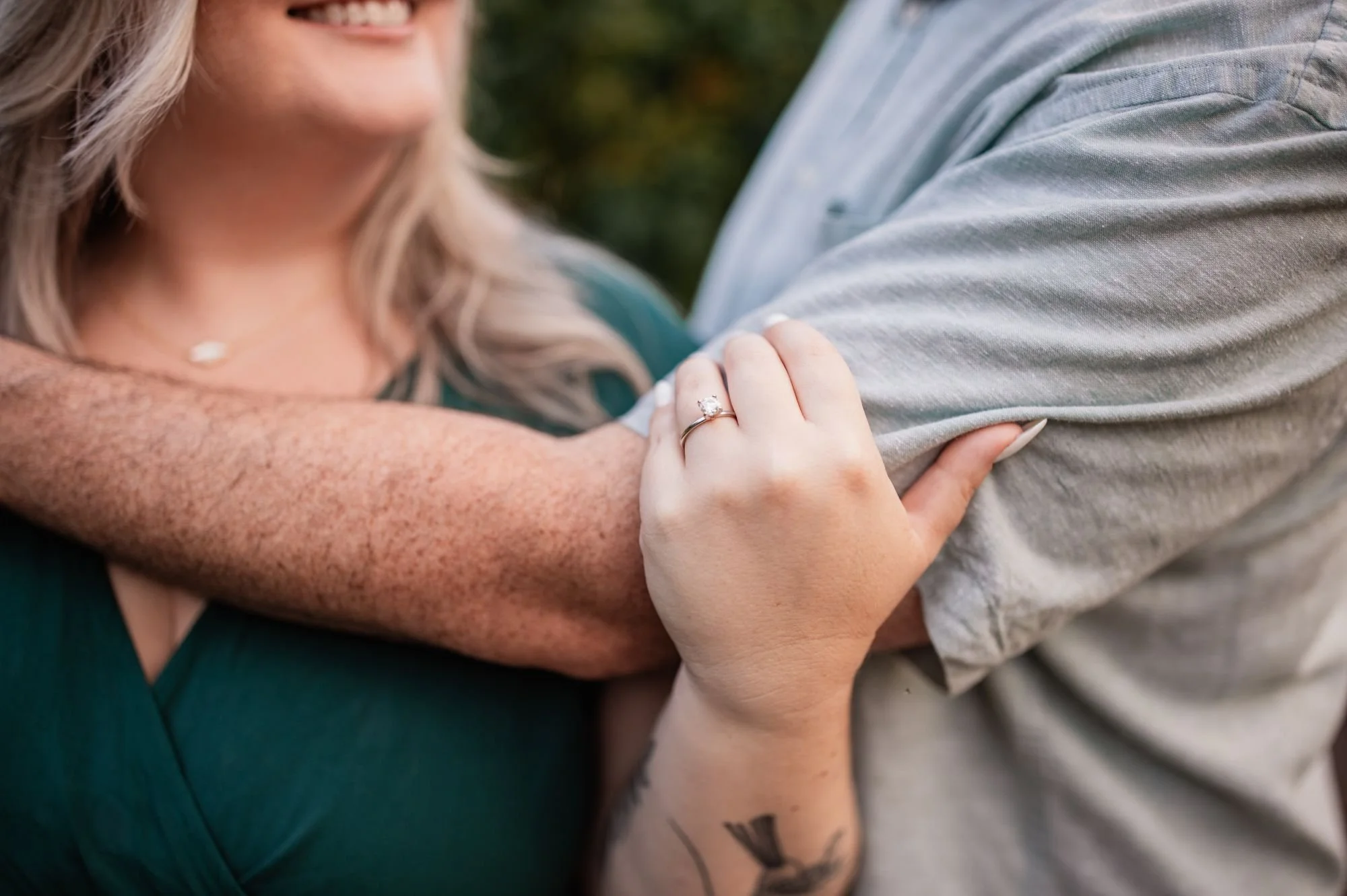 Close-up of an engagement ring as the bride-to-be holds her fiancé during their engagement session.