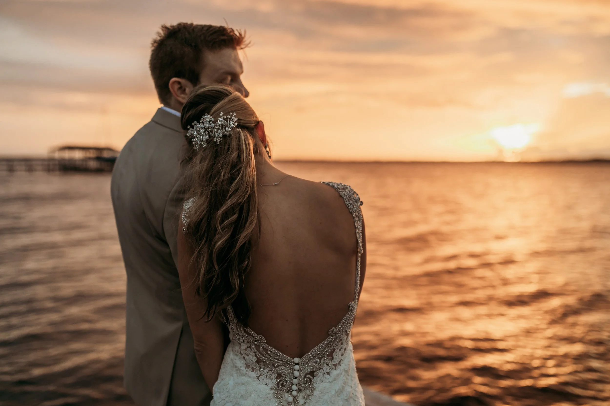 Intimate wedding moment at La Venture Grove in St. Augustine, Florida with couple holding each other during golden hour by the water