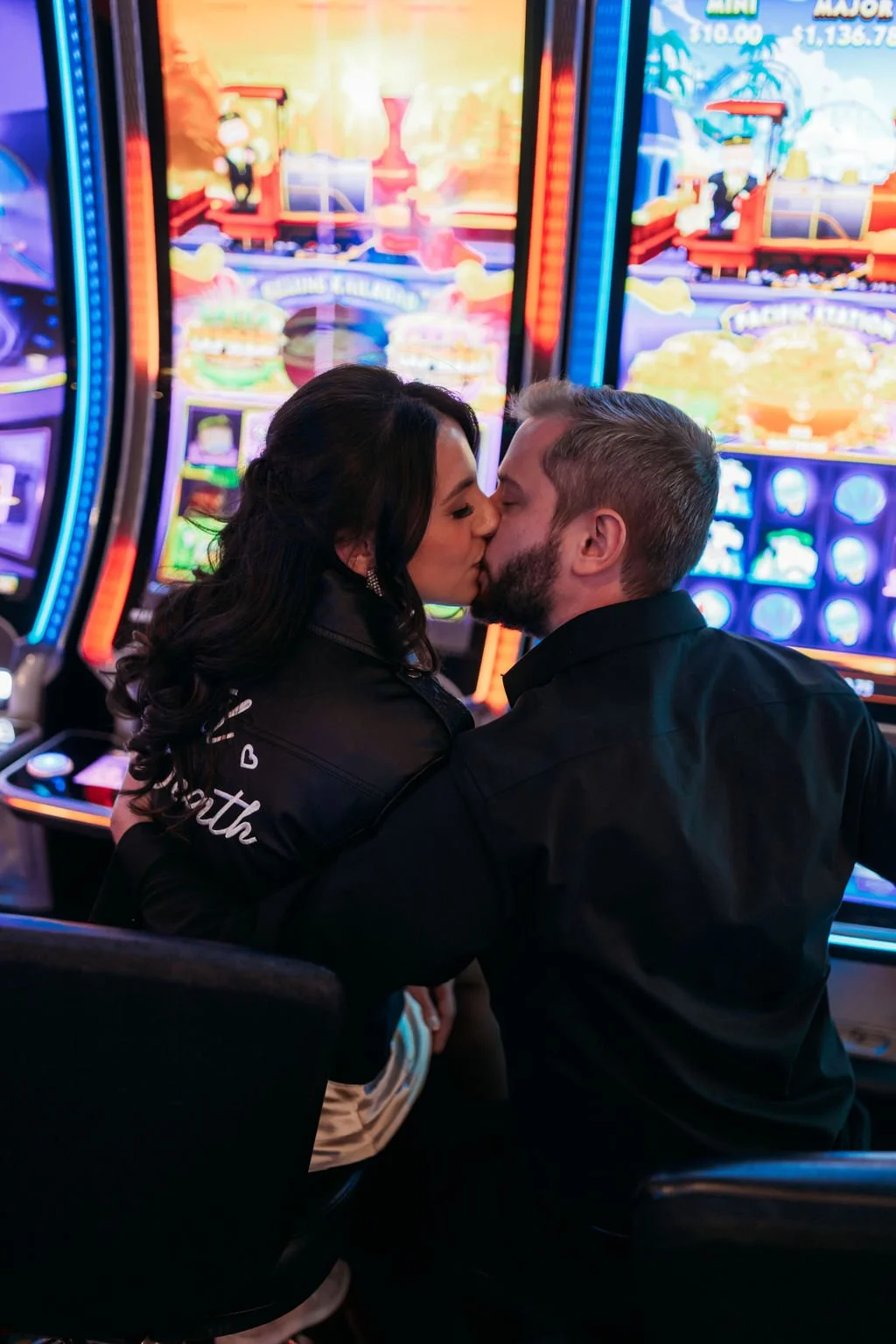 Stephanie and Gary embrace outside a glowing Fremont Street casino