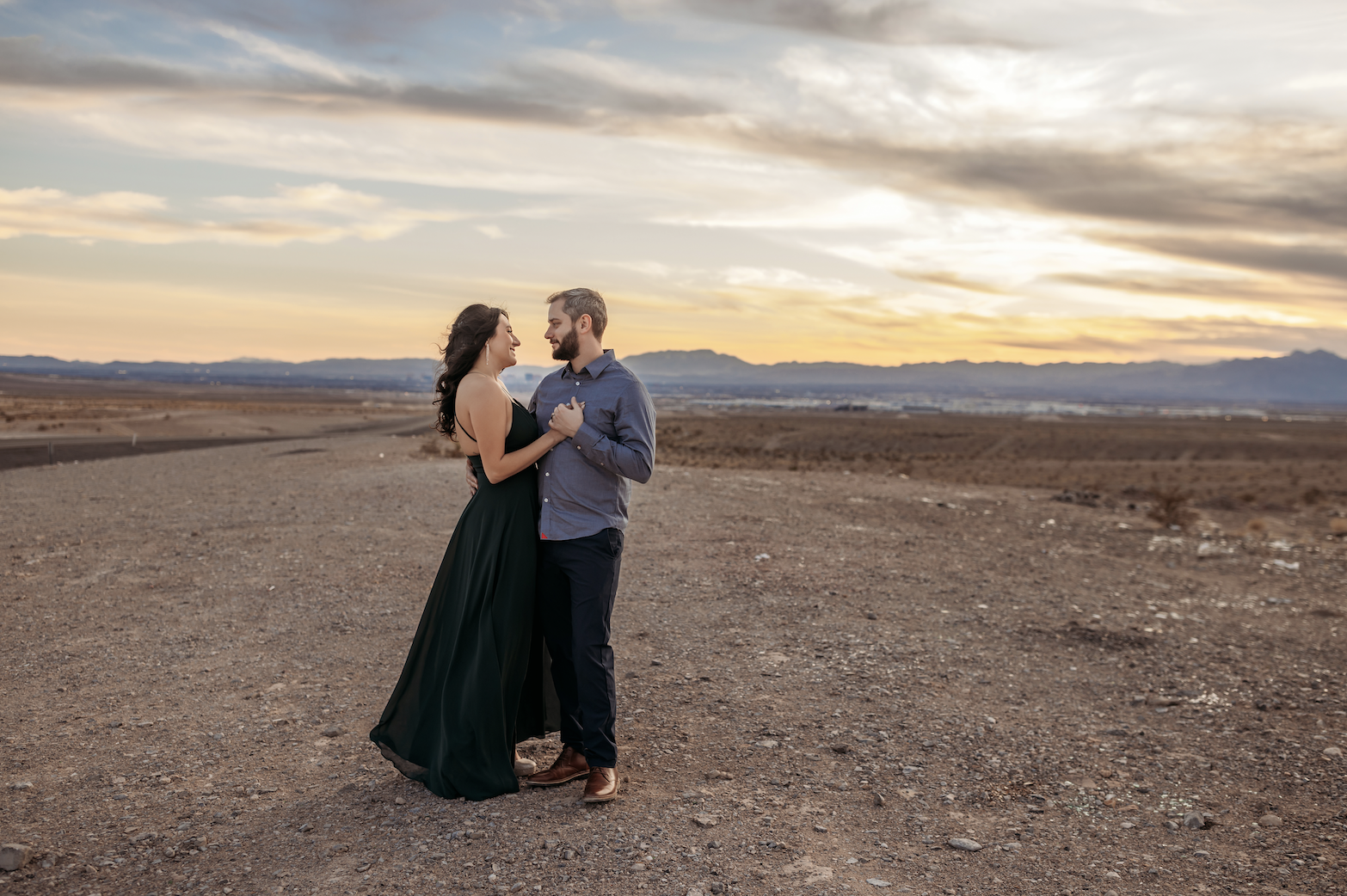 The newlyweds stand together in the Las Vegas desert during golden hour