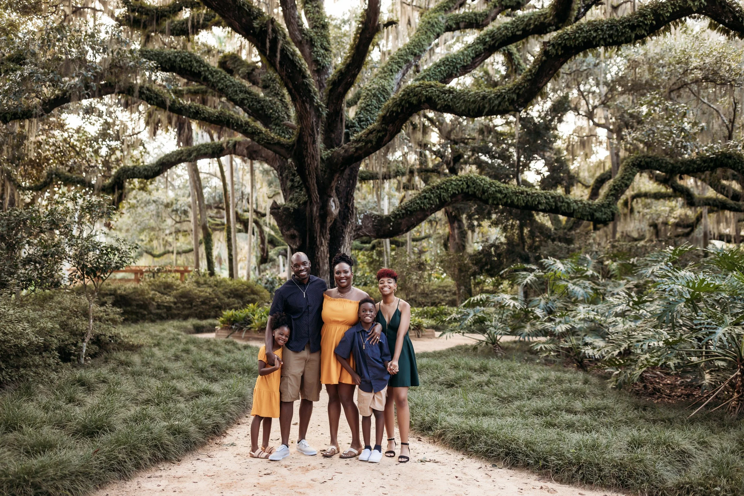 Family posing under oak trees during outdoor session at Washington Oaks State Park in Palm Coast Florida