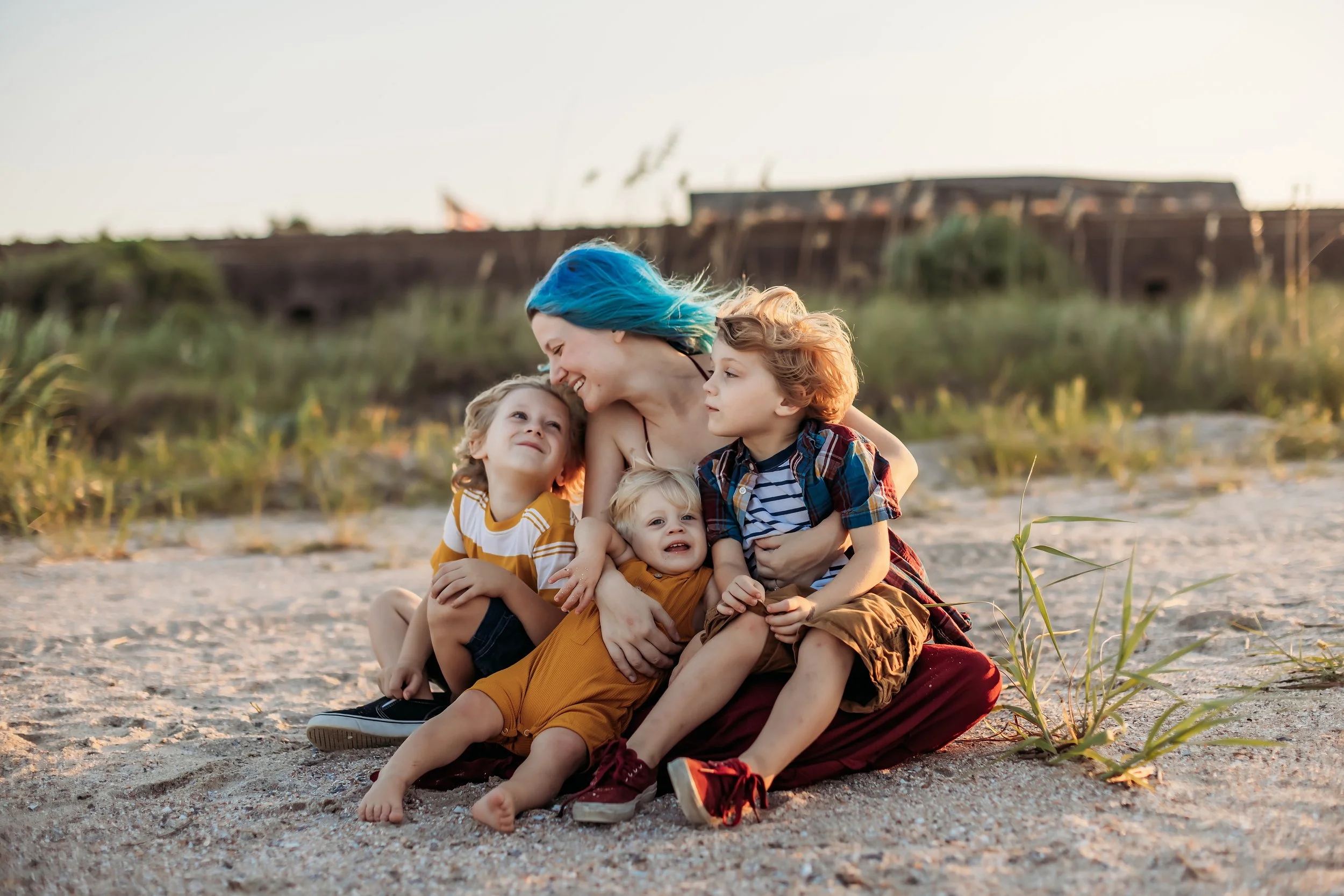 Jacksonville Florida family photographer Tiffany Joyce sitting on the beach with her three young children during a candid family moment