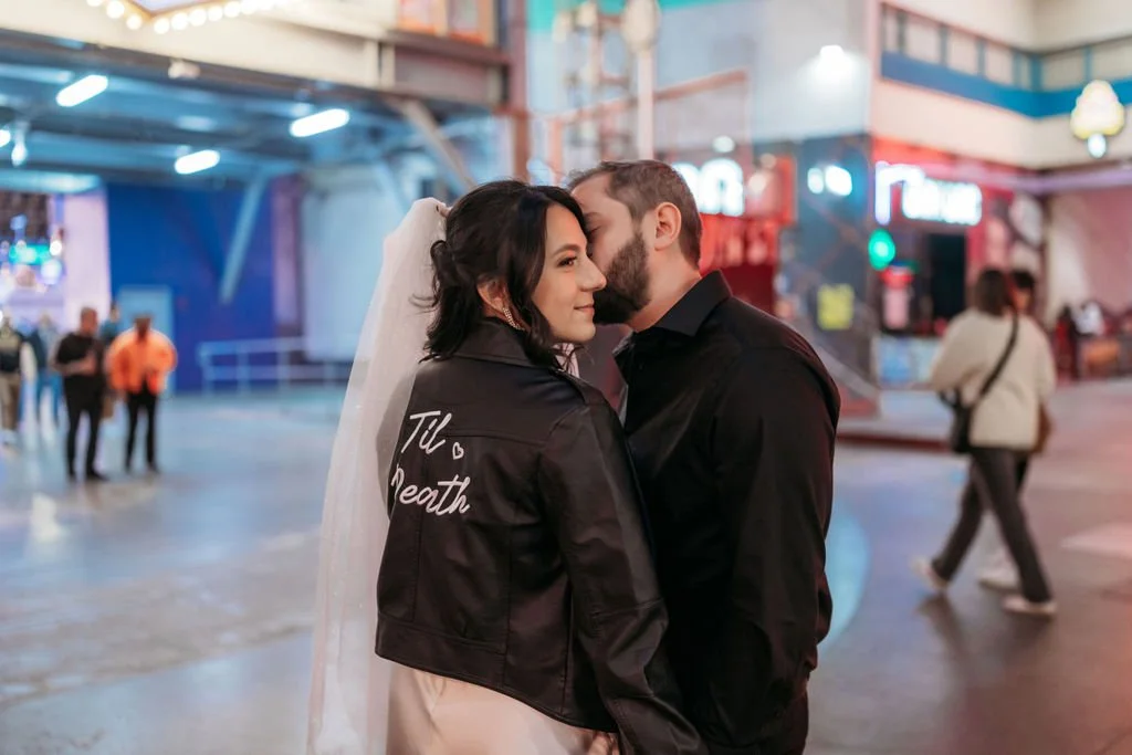 The newlyweds pose together on Fremont Street during their Las Vegas elopement