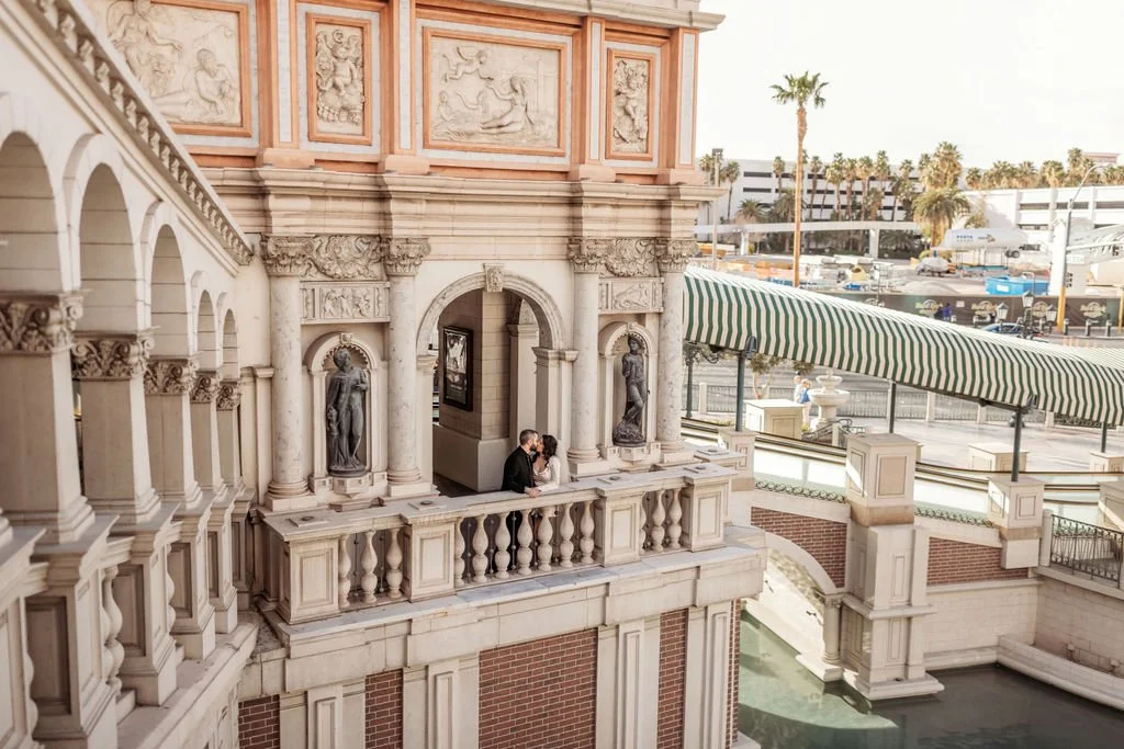 Stephanie and Gary embrace beneath the ornate architecture of the Venetian