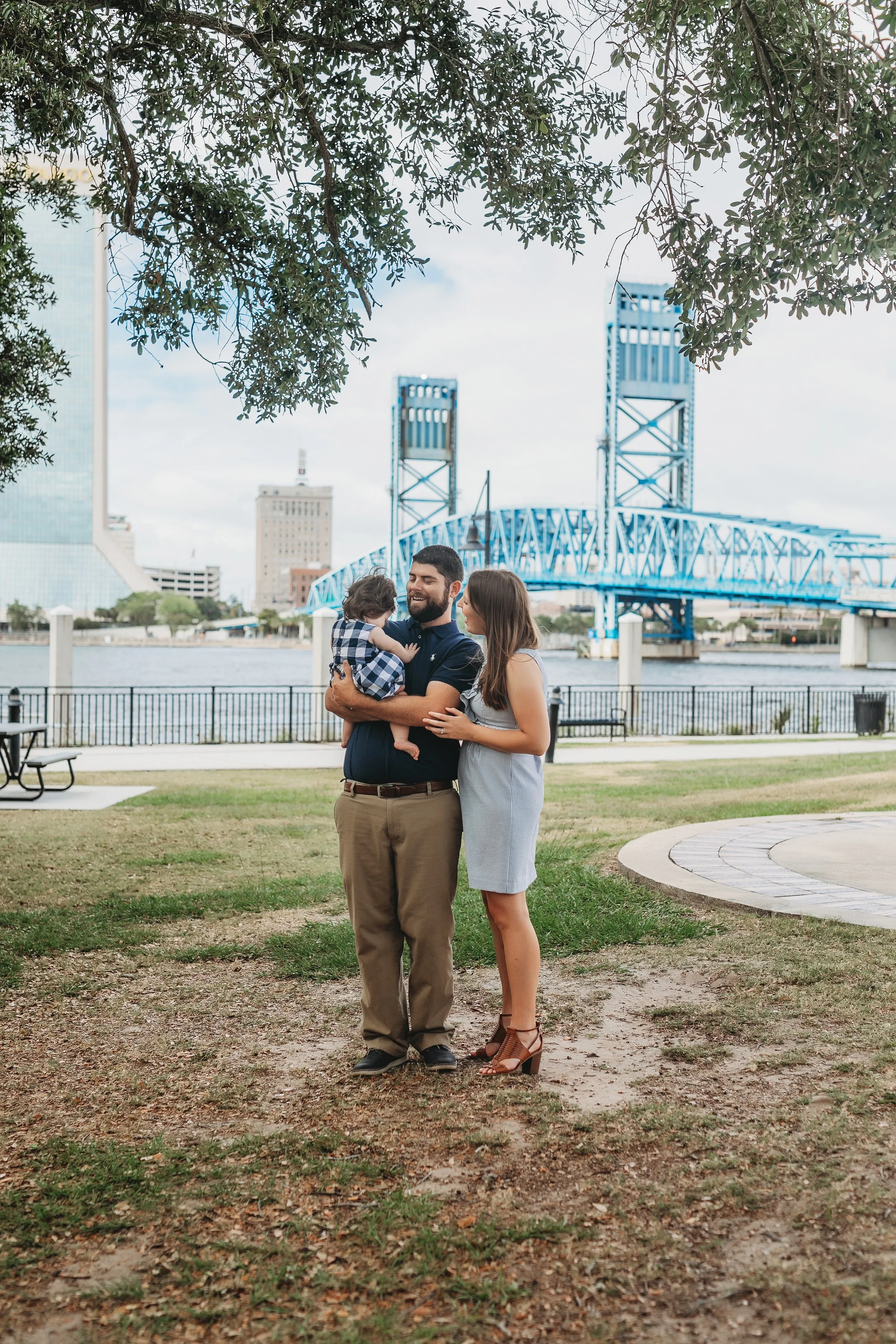 Young family standing near Friendship Fountain in downtown Jacksonville Florida with the city skyline in the background