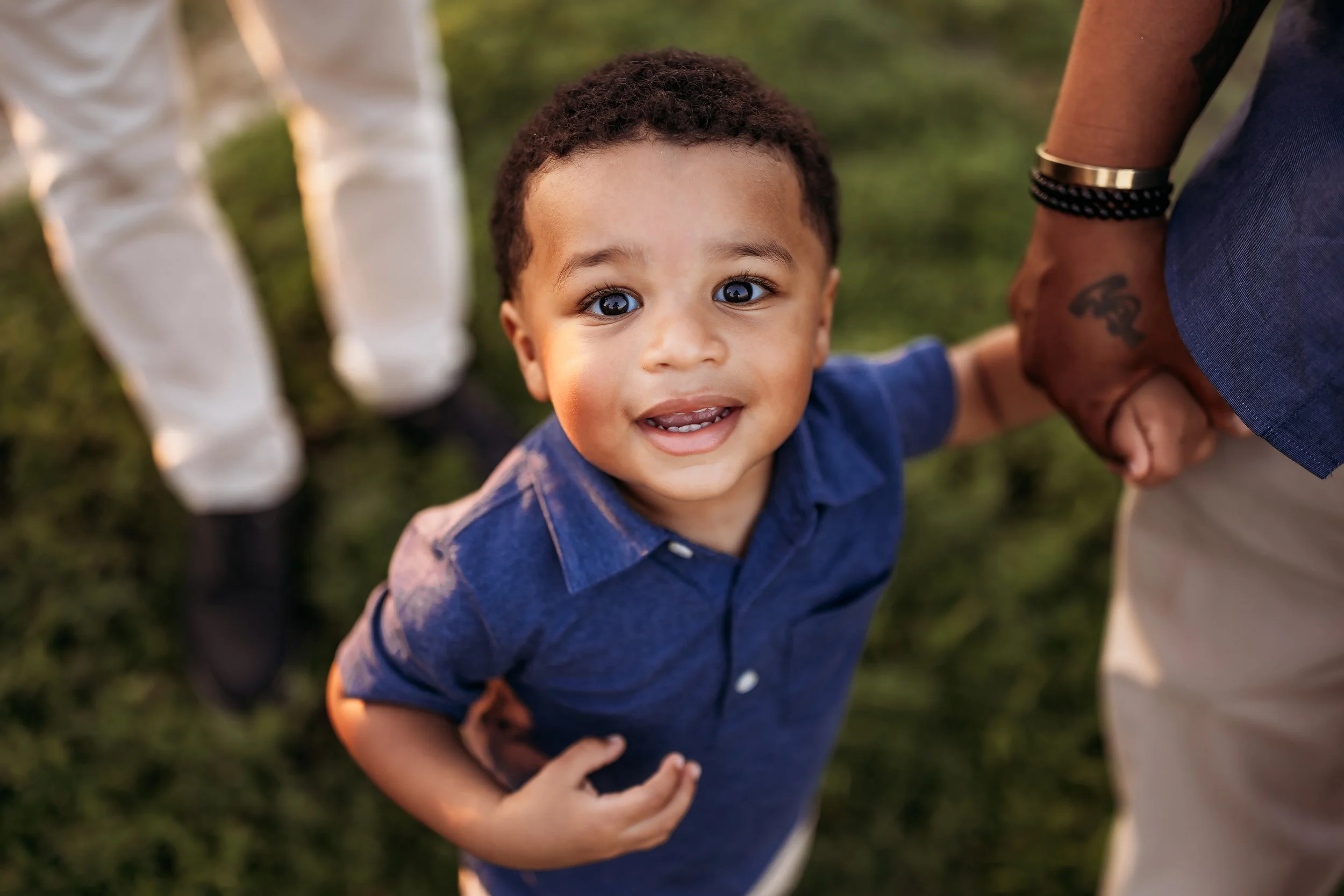 Close up of smiling baby holding parent’s hand during outdoor family session in Jacksonville Florida