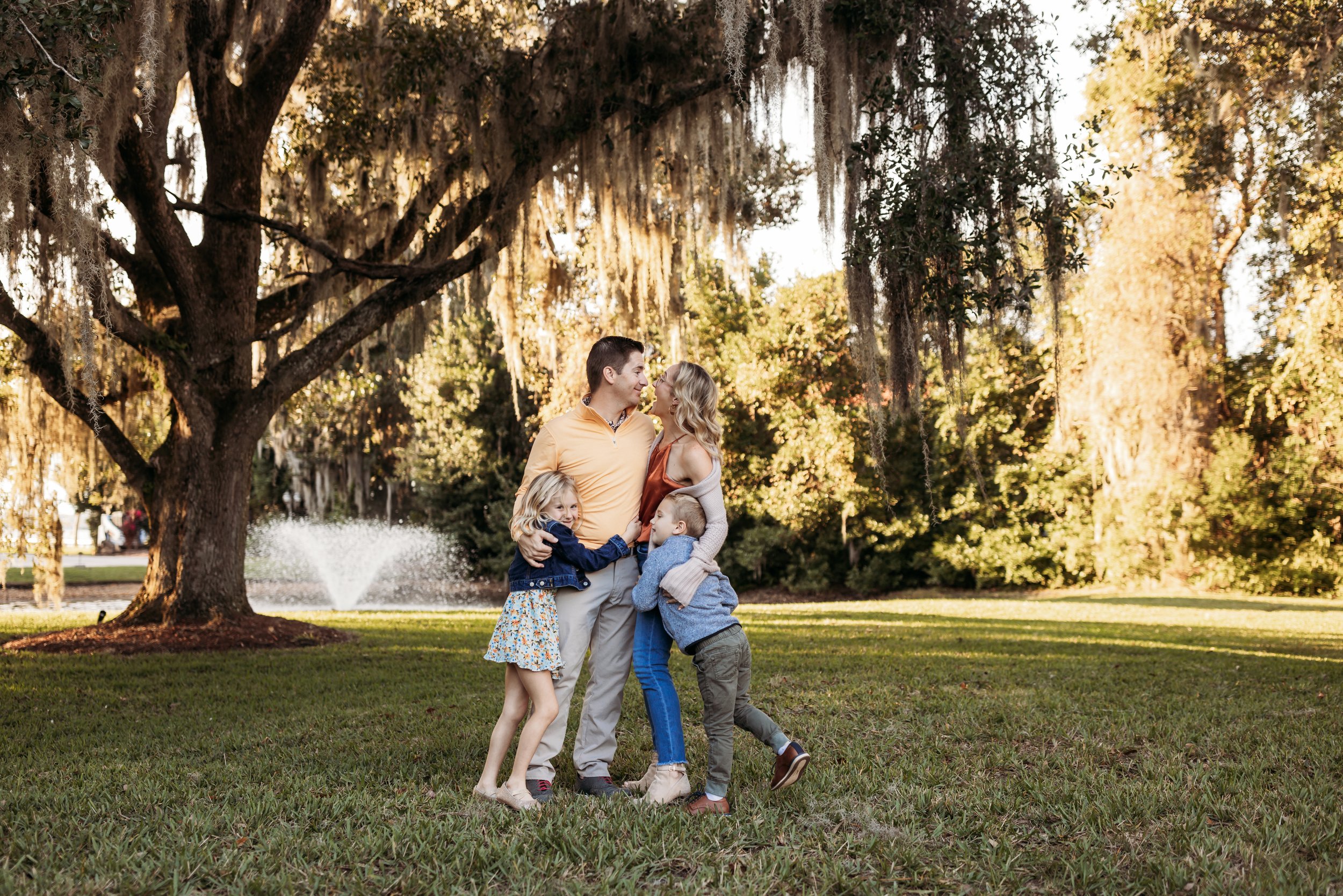 Family of four smiling together on the sand dunes at Julington Creek in Jacksonville Florida during sunset
