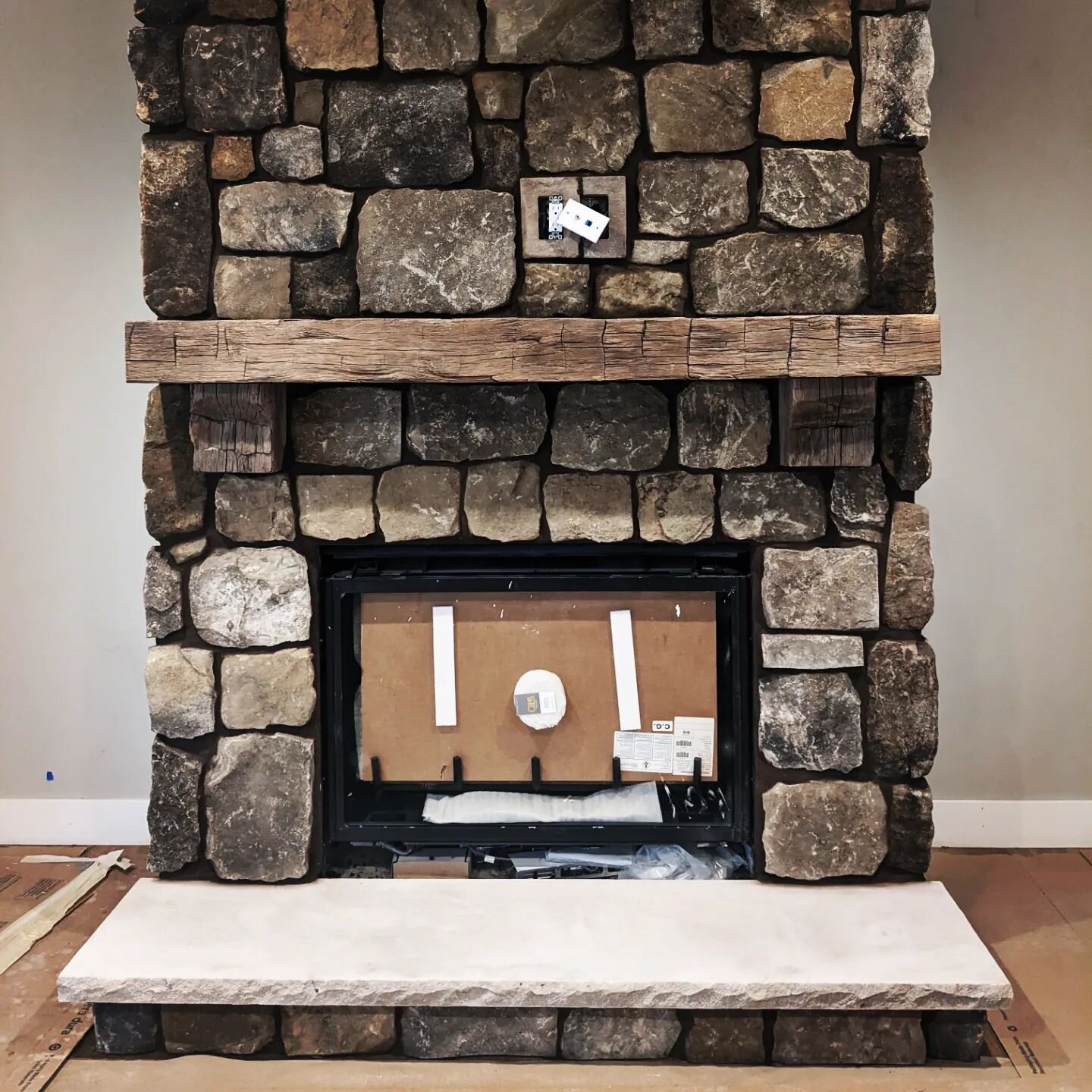 This cozy fireplace was laid with real stone veneer. It's a type of sandstone that has all sorts of contrasting vibrant colors and the dark brown mortar really brings that out.