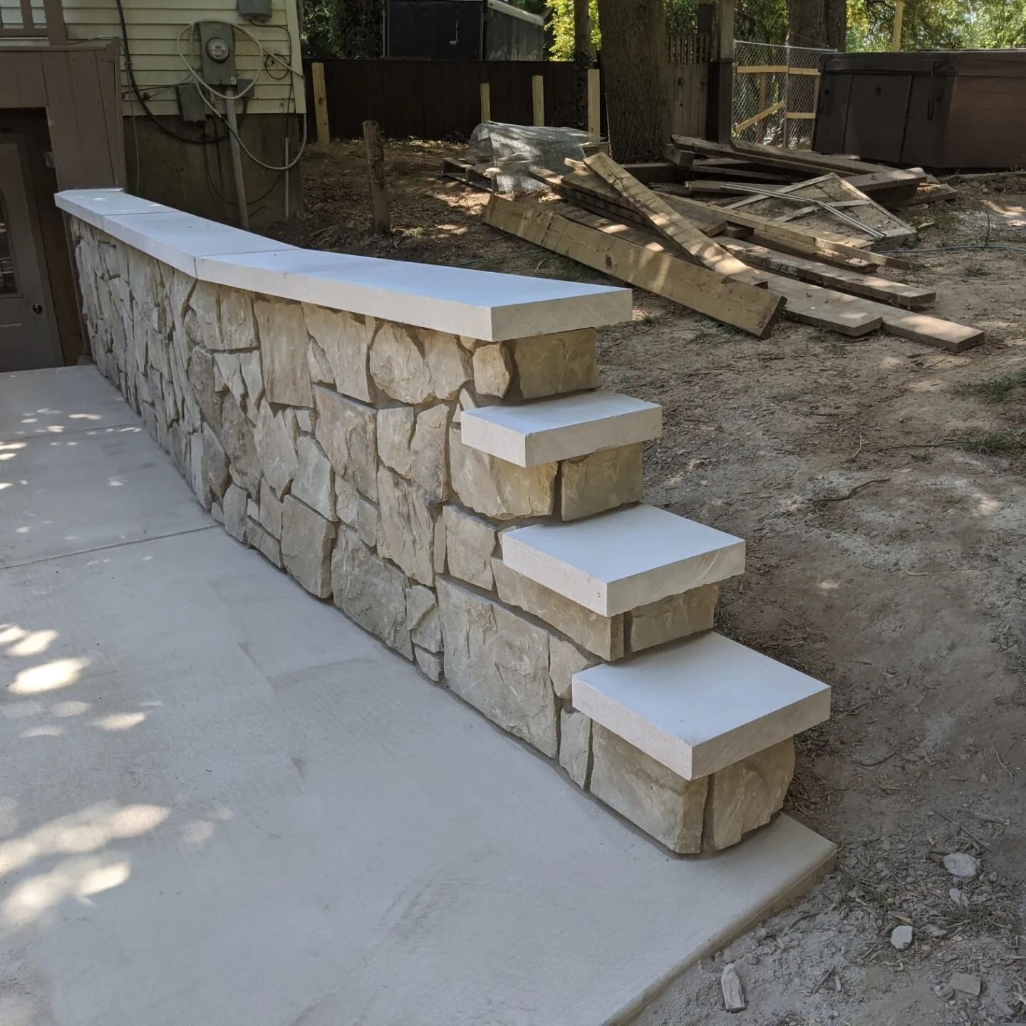 Real stone veneer wall with a limestone cap