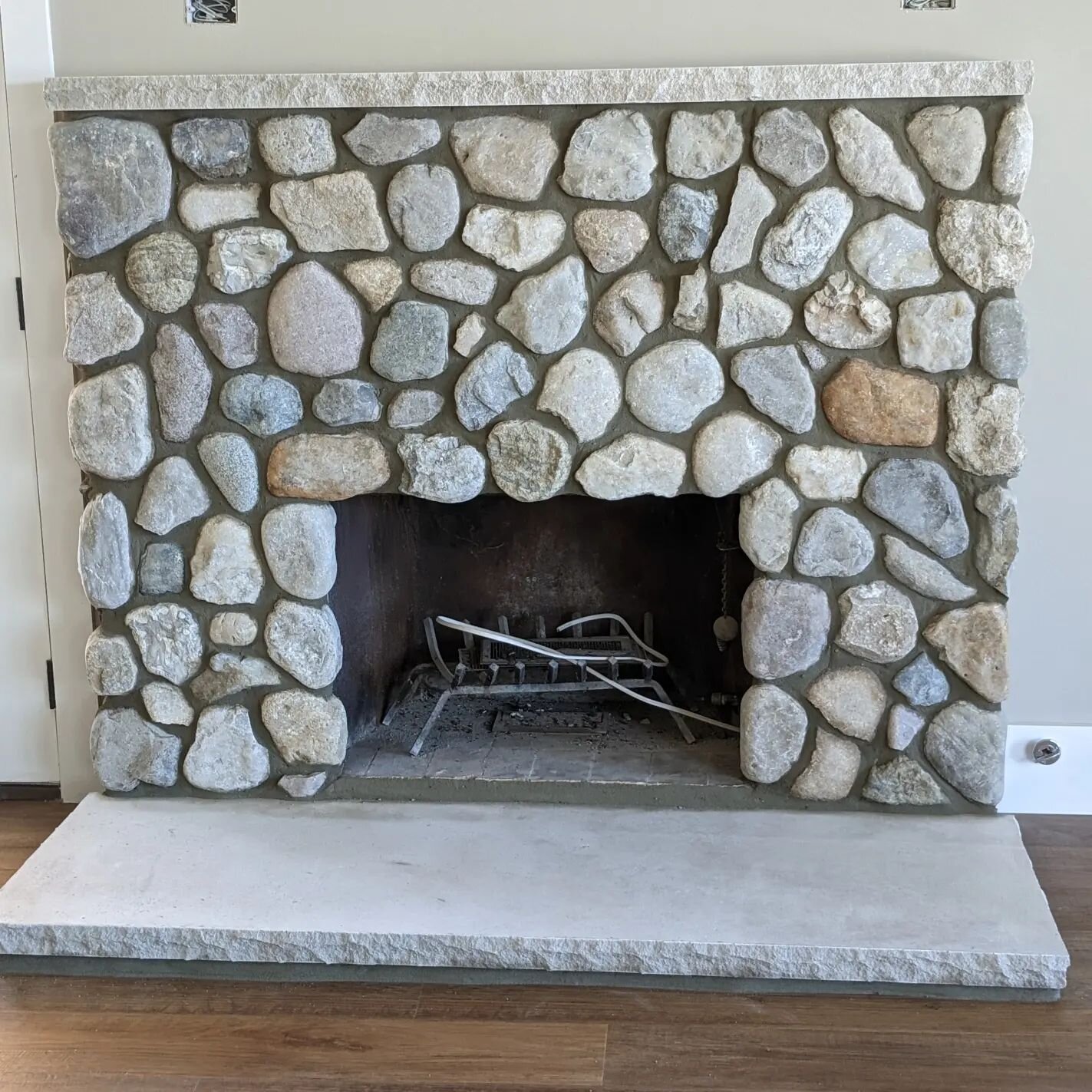 Mantel high stone fireplace. This is real stone veneer fieldstone with a custom cut limestone mantel on top and a cut limestone piece for the hearth