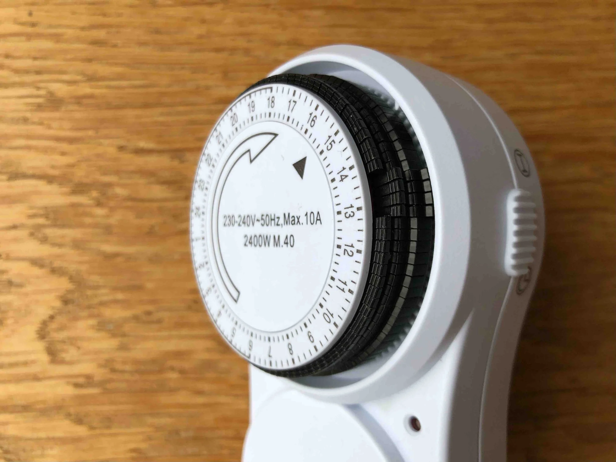 Close-up of the rotating 24-hour dial on a mechanical plug timer.
