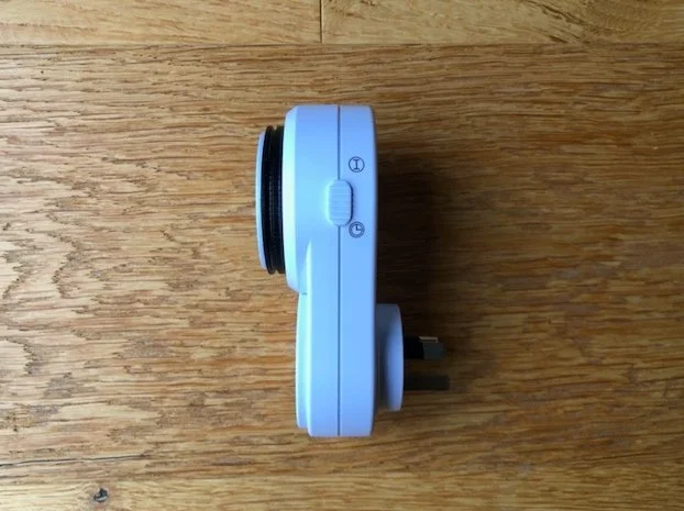 Mechanical plug-in timer with 24-hour rotating dial and manual override switch.