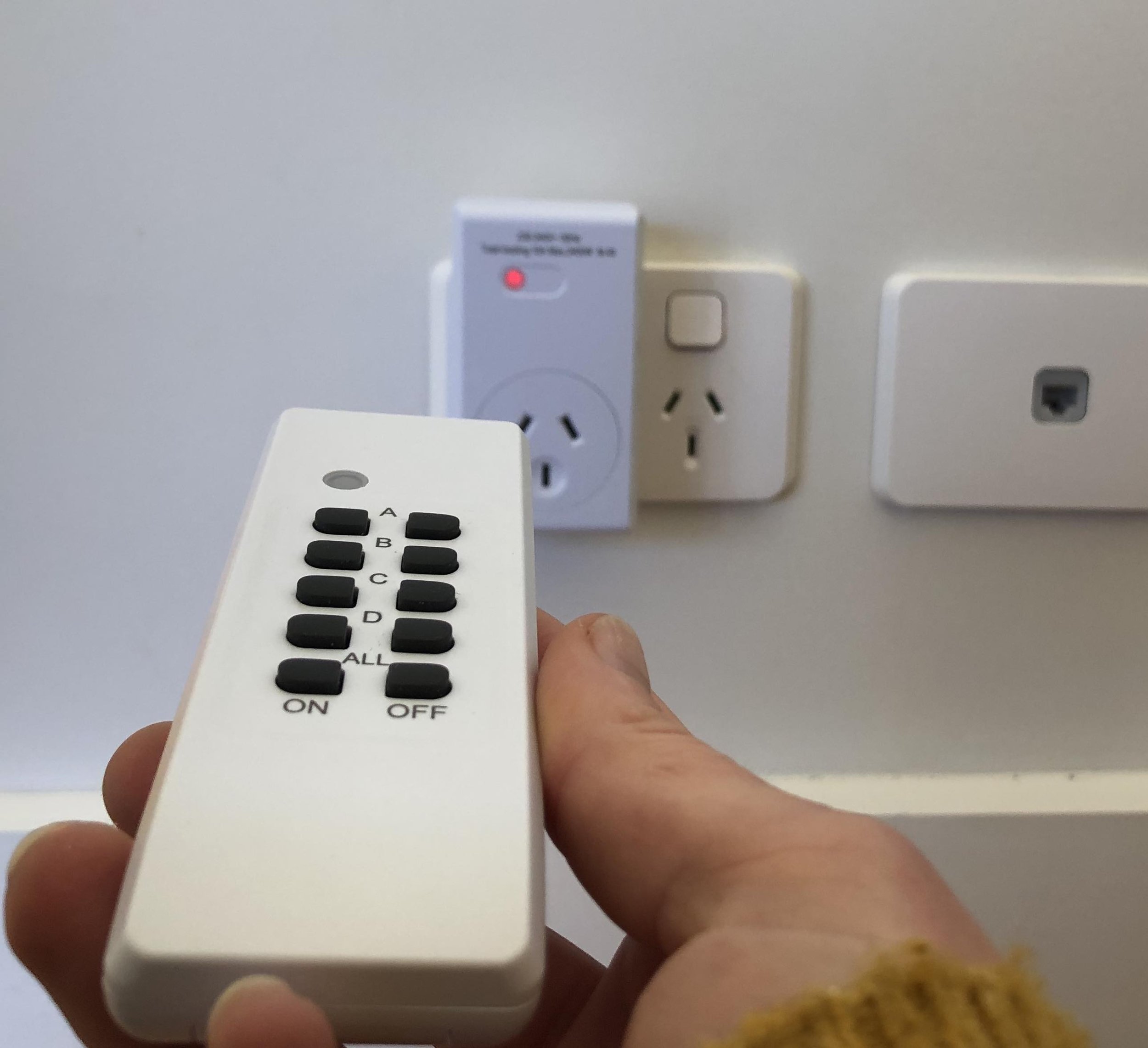 Remote controlled plug adaptor with handheld remote for New Zealand power outlets.