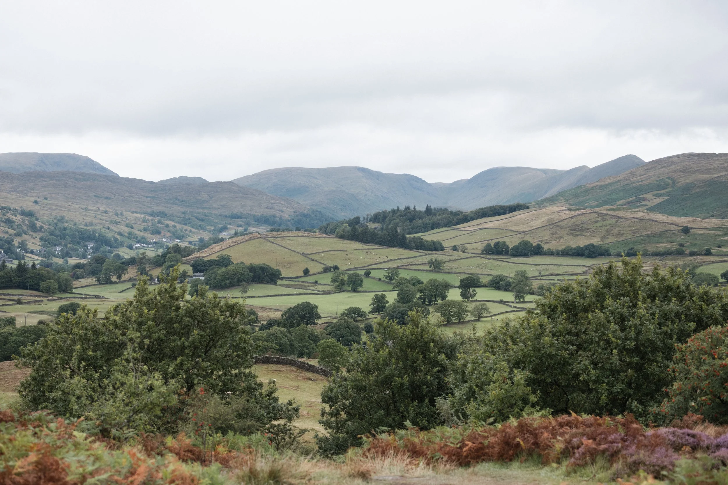 View across Windermere toward misty fells beneath an overcast sky.
