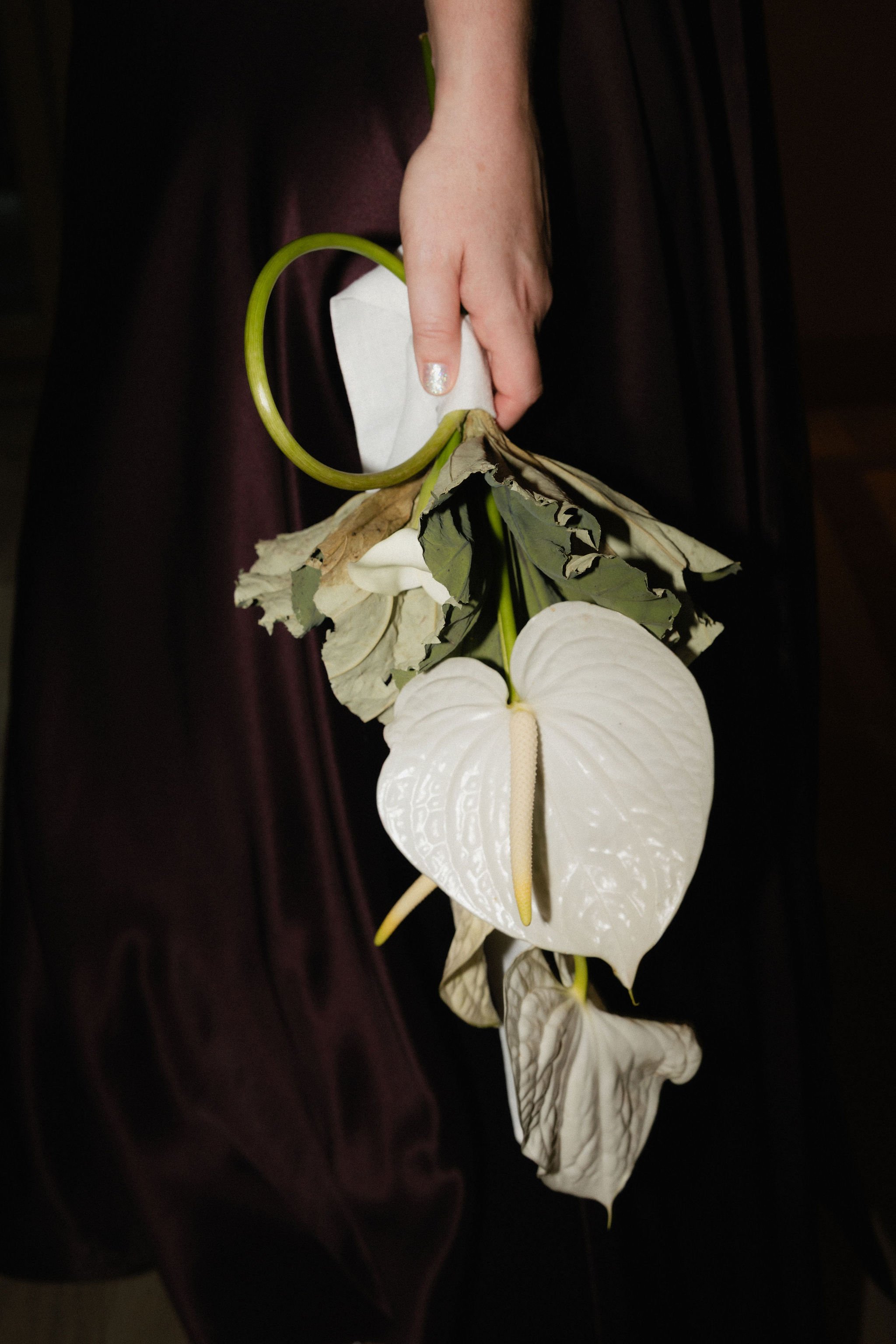 Floral arrangement with roses and baby's breath next to a drink menu and a small candle.