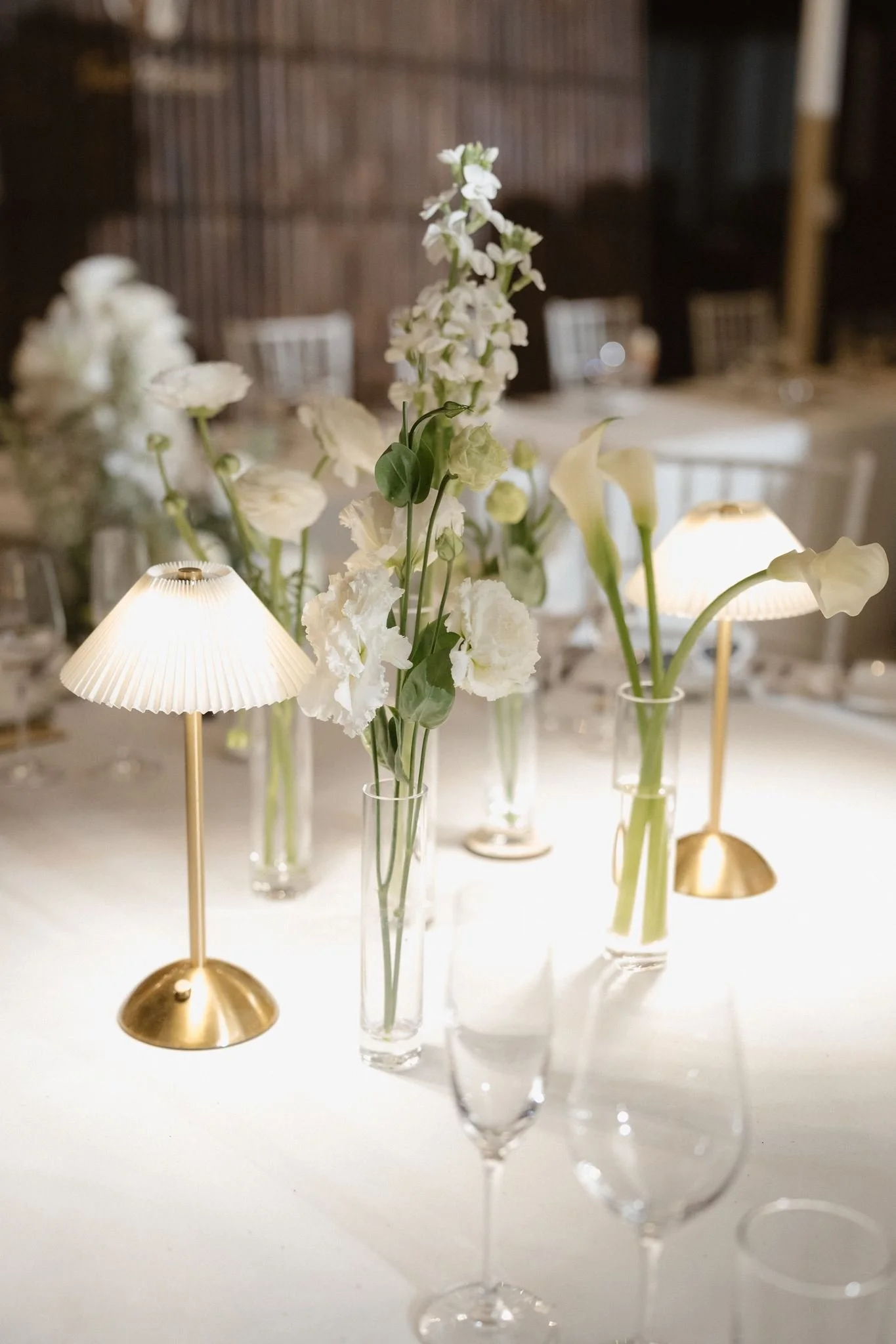 Floral arrangement with roses and baby's breath next to a drink menu and a small candle.