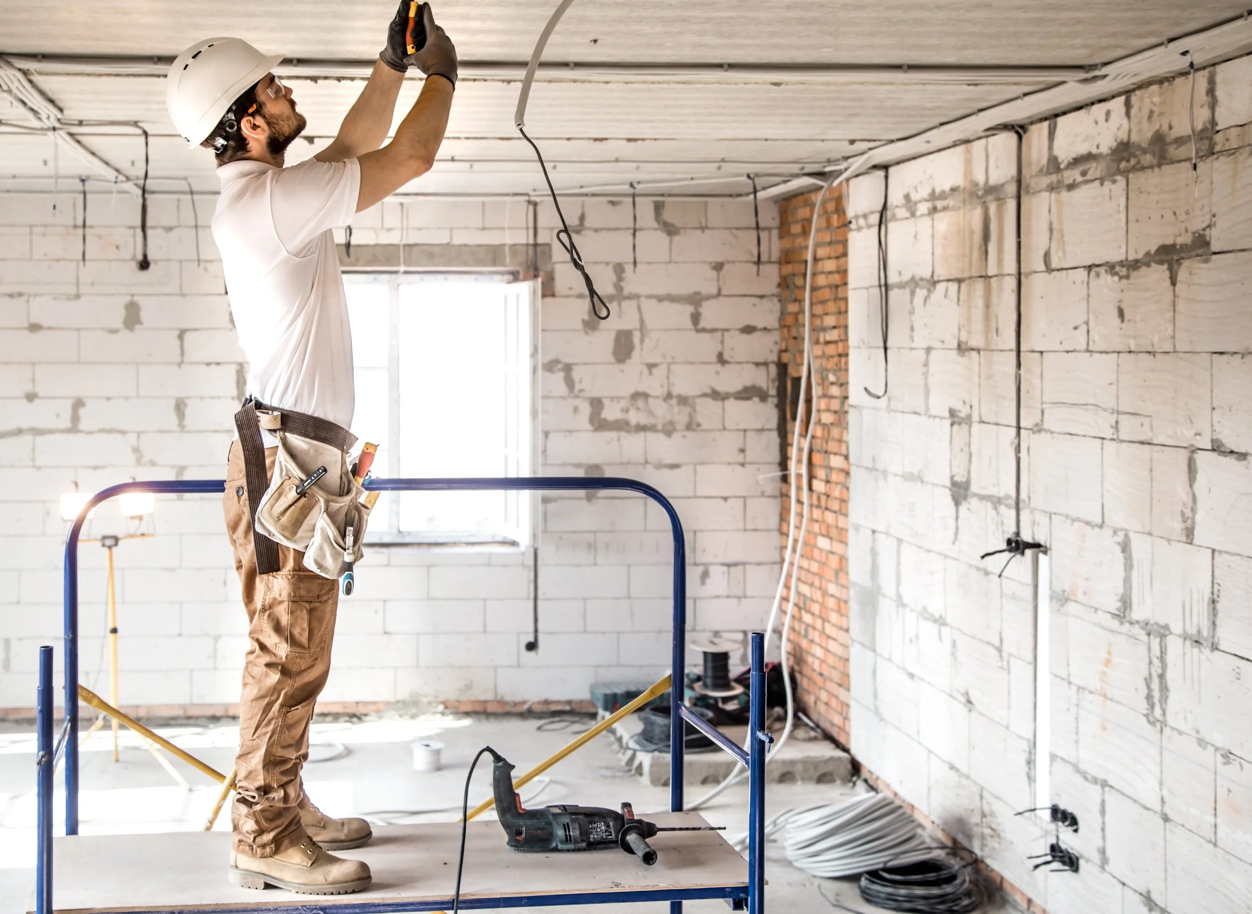 electrician-installer-with-tool-his-hands-working-with-cable-construction-site.jpg