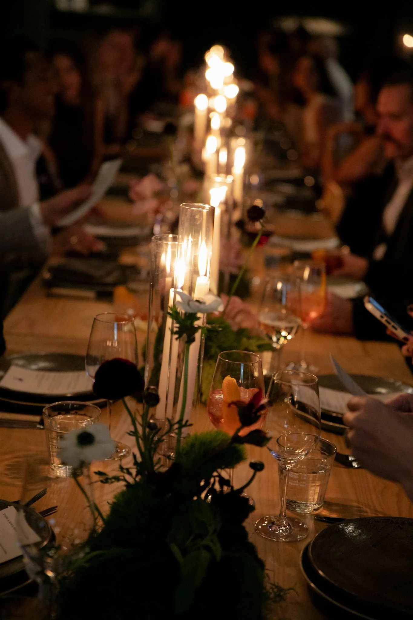 Wedding guests at a candlelit rehearsal dinner at Maxwells Trading Chicago wedding venue.