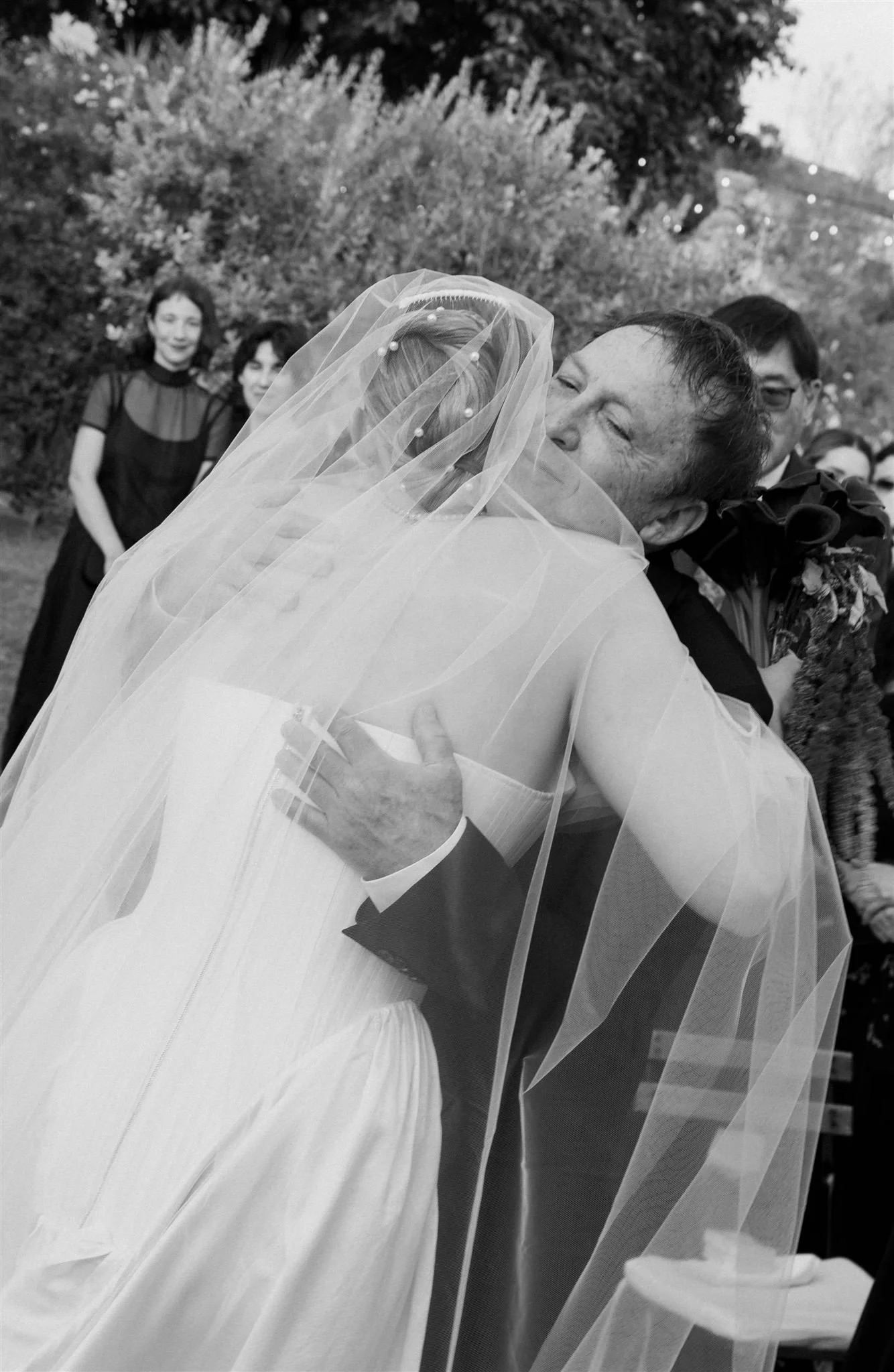 Father of the bride hugging the bride at the wedding ceremony on a wedding day at Villa Medicea Di Lilliano in Tuscany, Italy.