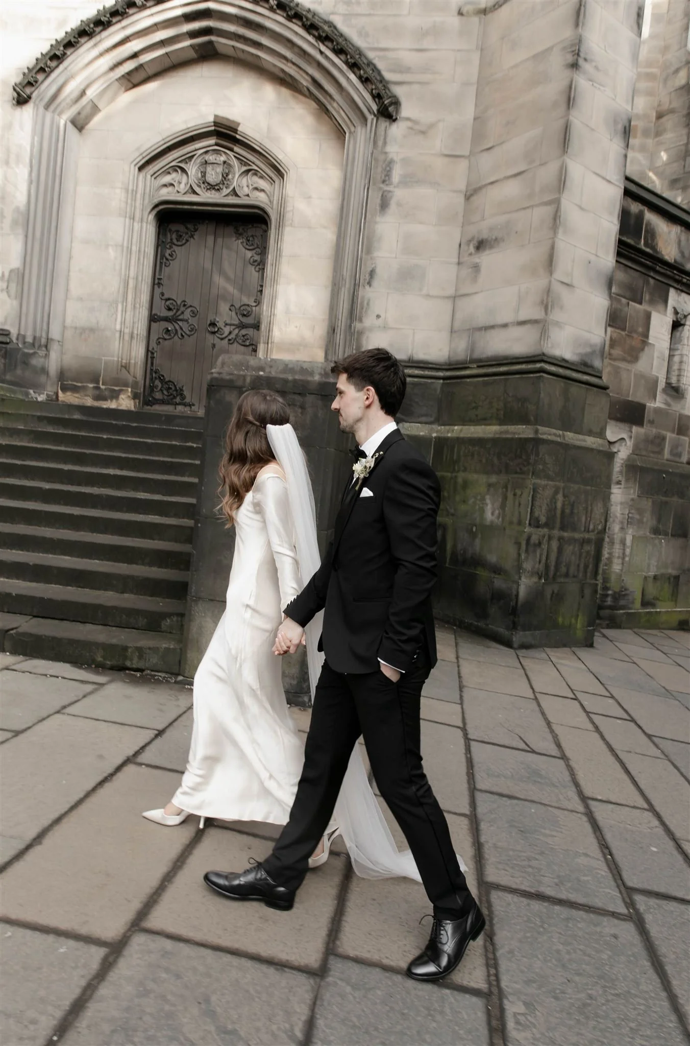 Wedding couple celebrating outside Edinburgh City Chambers, captured by an Edinburgh City Chambers wedding photographer in a natural style.