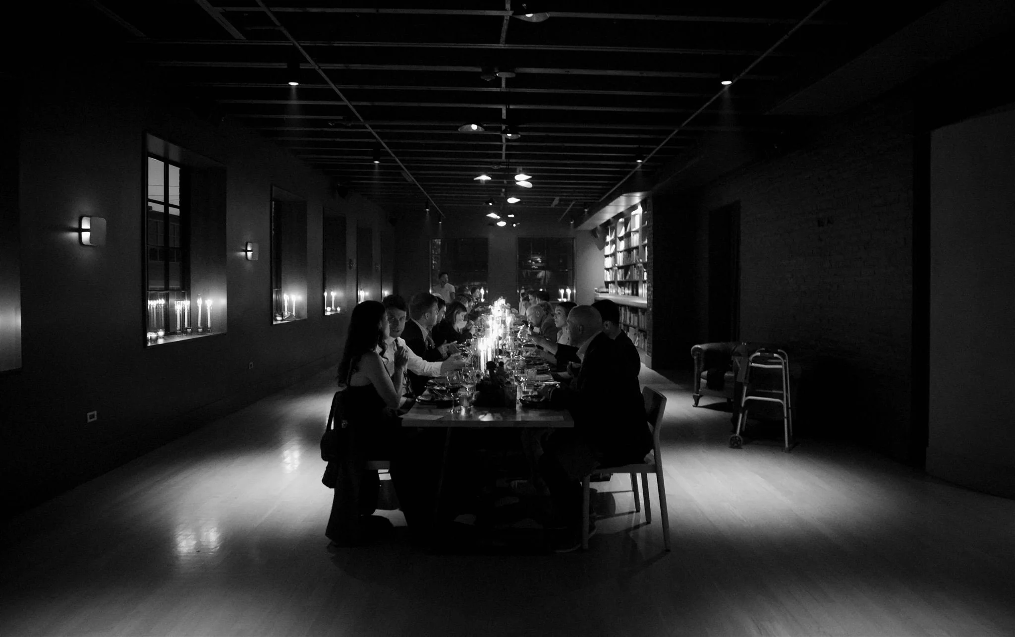 Wedding guests at a candlelit rehearsal dinner at Maxwells Trading Chicago wedding venue.