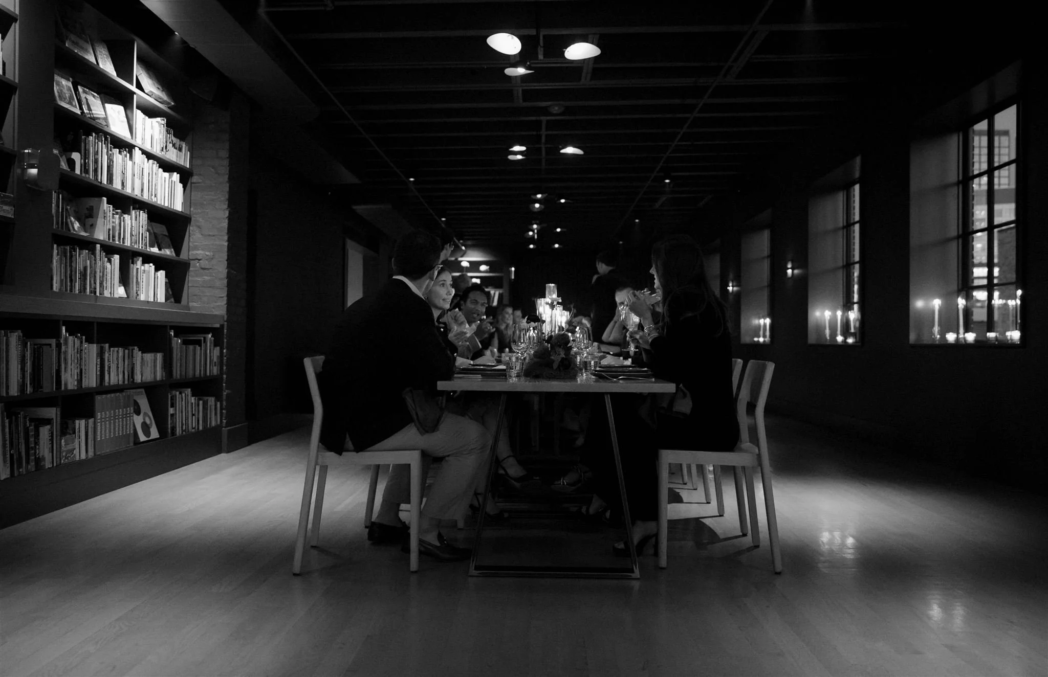 Wedding guests at a candlelit rehearsal dinner at Maxwells Trading Chicago wedding venue.