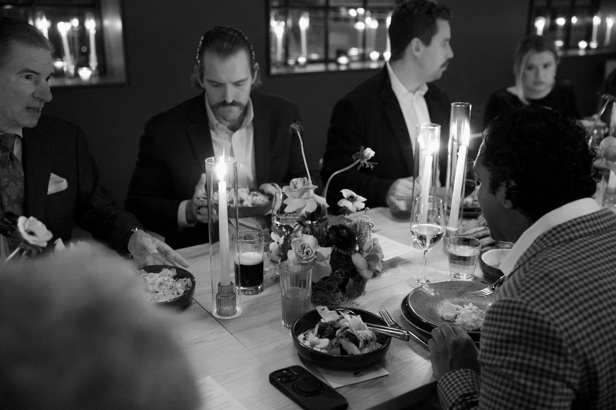 Wedding guests at a candlelit rehearsal dinner at Maxwells Trading Chicago wedding venue.