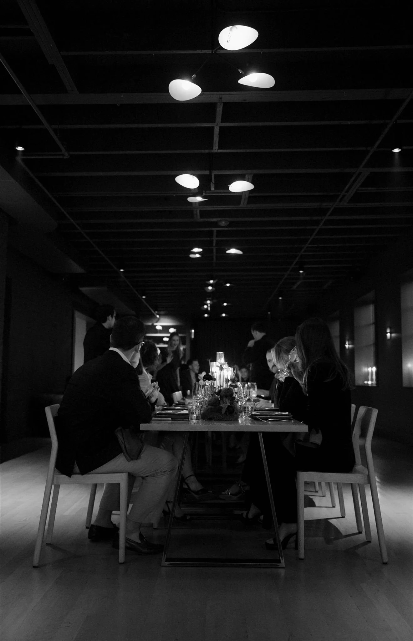 Wedding guests at a candlelit rehearsal dinner at Maxwells Trading Chicago wedding venue.