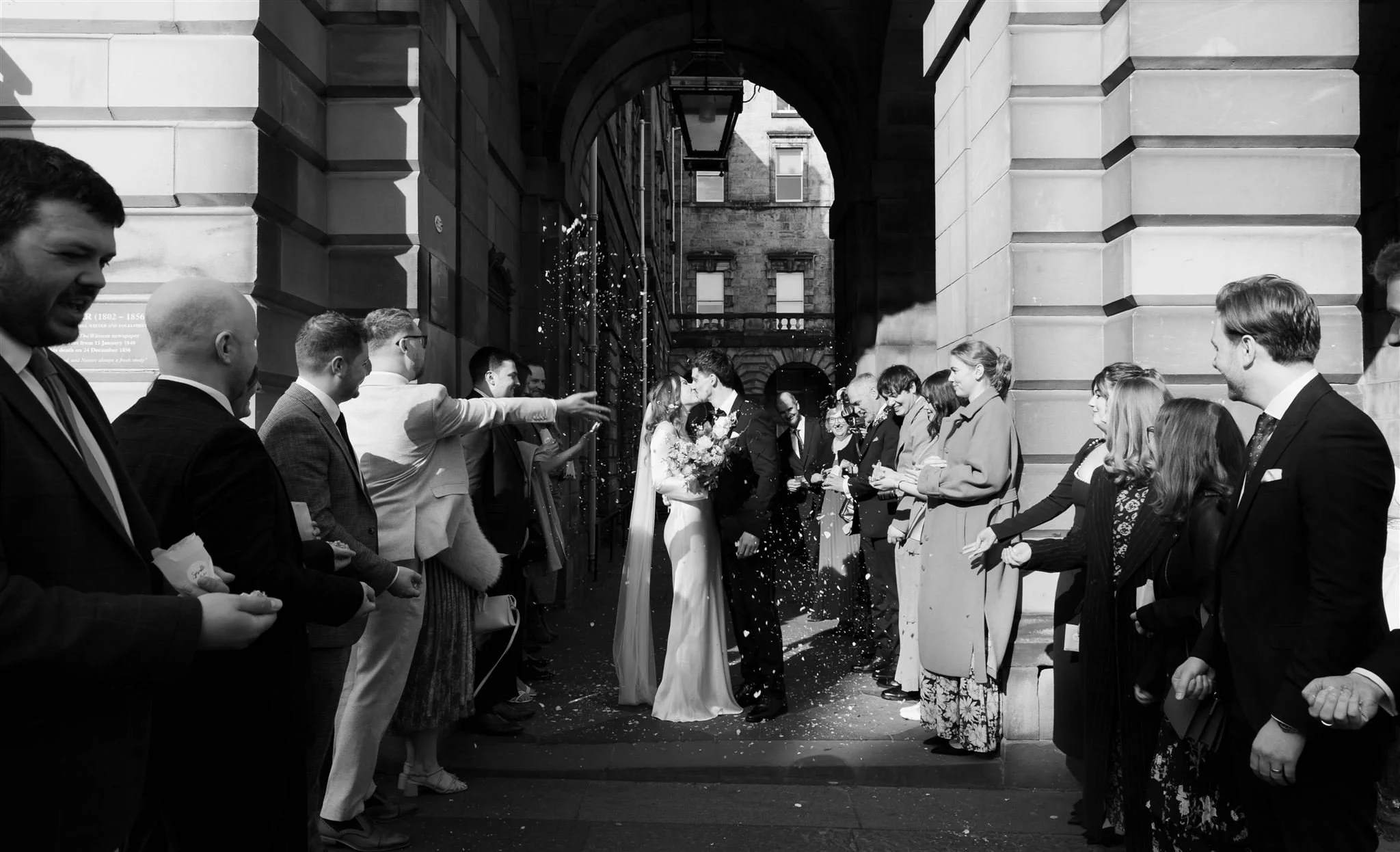 Wedding couple celebrating outside with confetti at Edinburgh City Chambers, captured by an Edinburgh City Chambers wedding photographer.