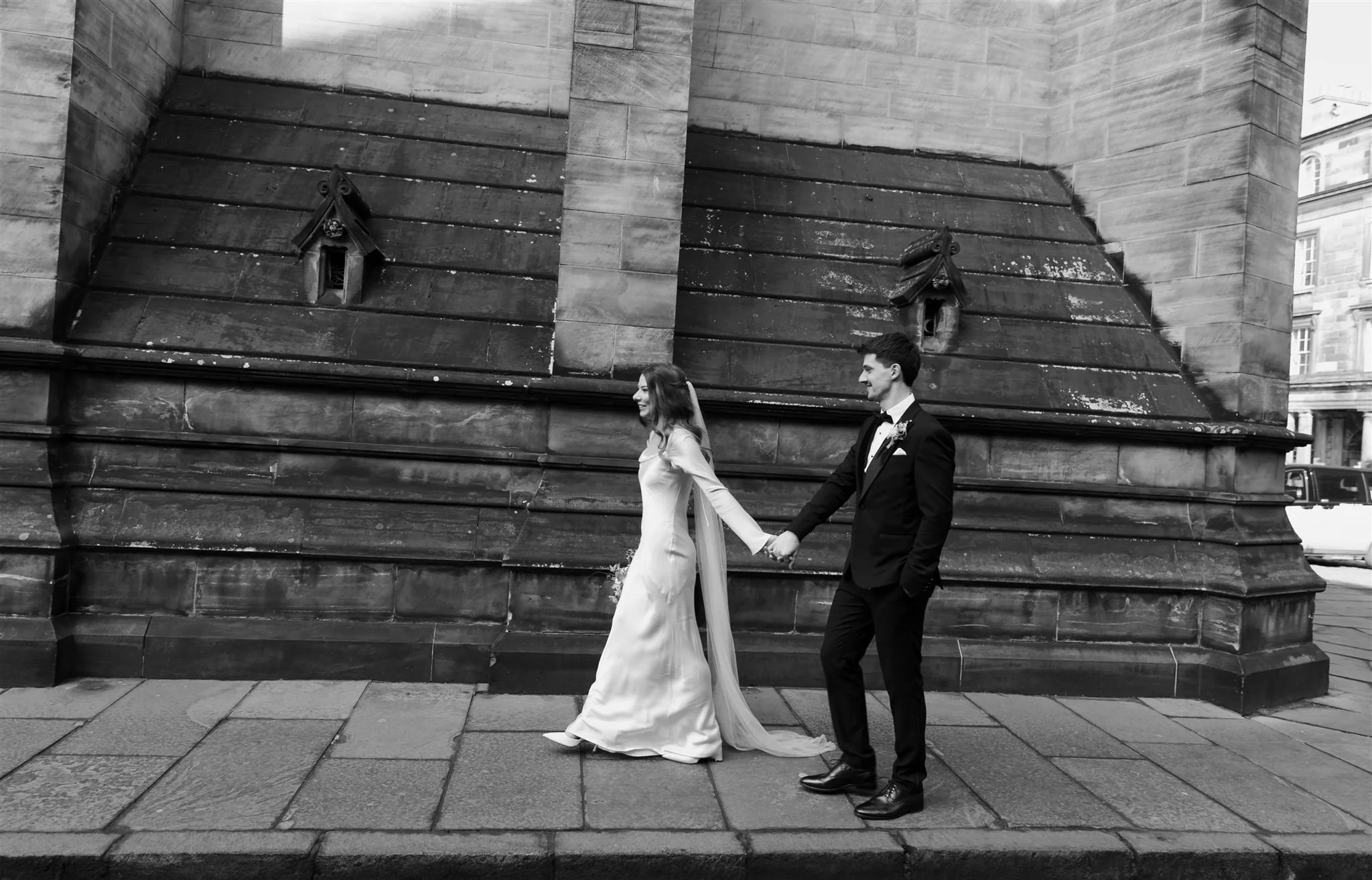 Bride and groom outside Edinburgh City Chambers and St. Giles Cathedral on their wedding day in Edinburgh.