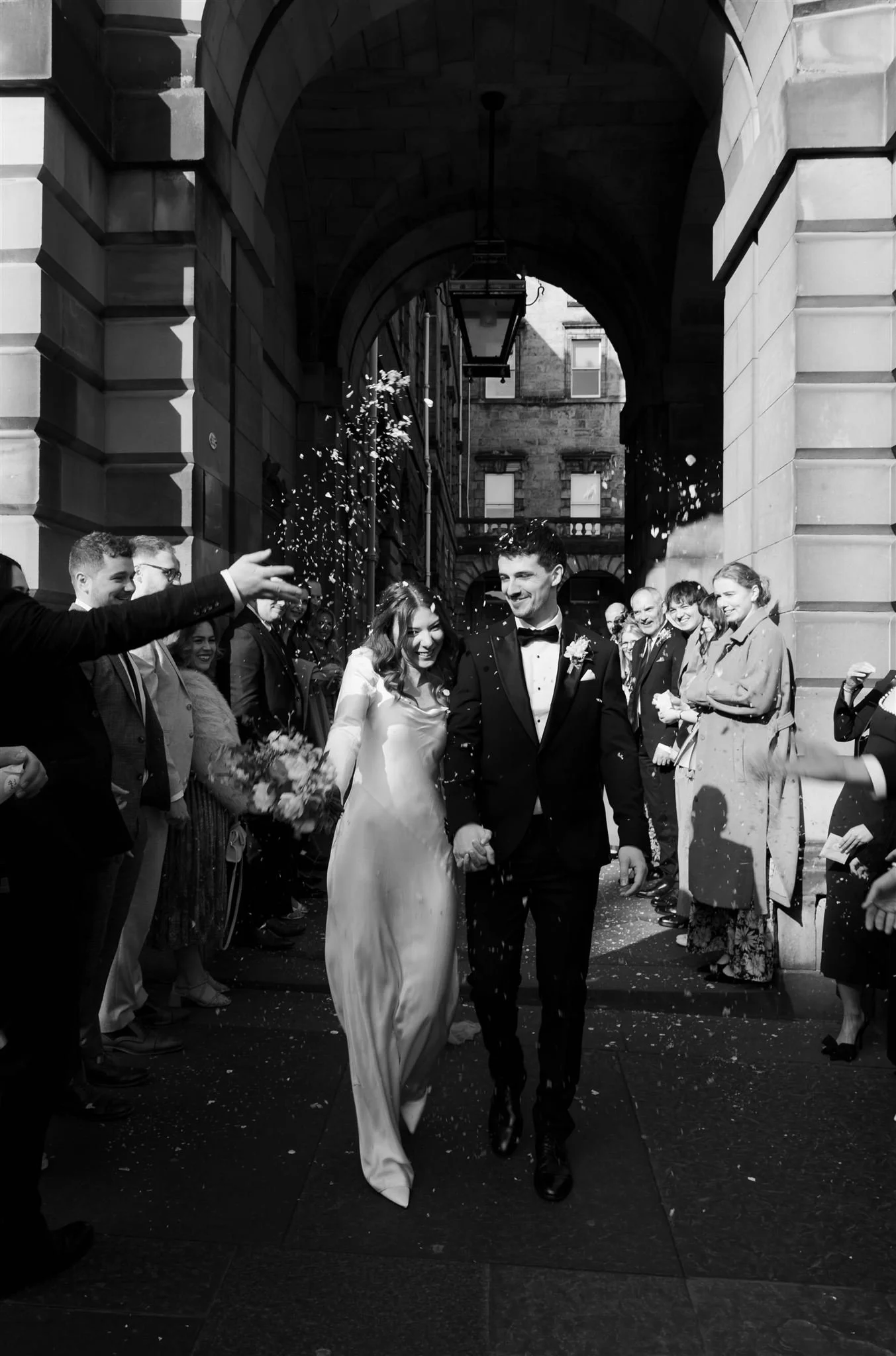 Wedding couple celebrating outside Edinburgh City Chambers, captured by an editorial style Edinburgh City Chambers wedding photographer.