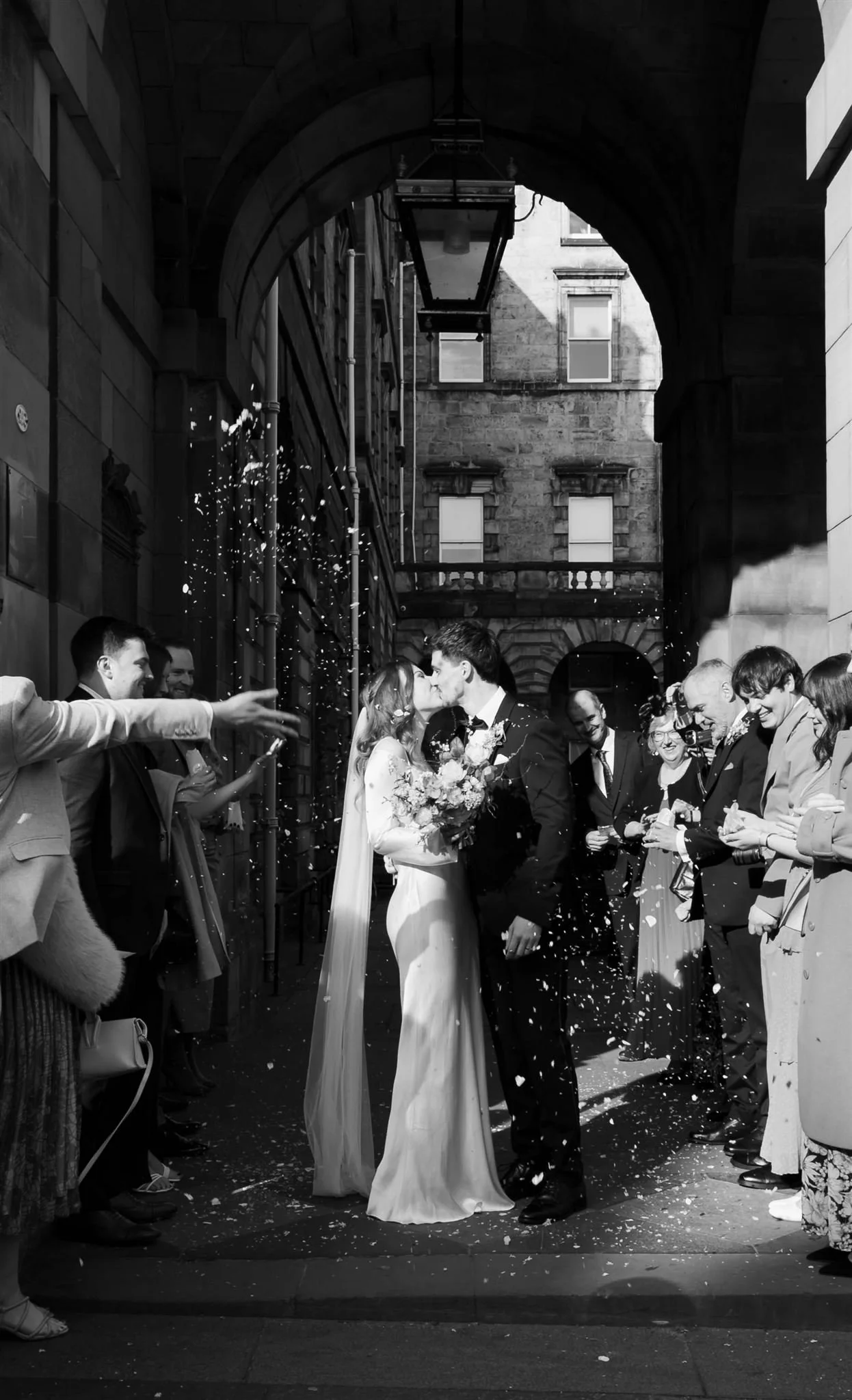 Wedding couple celebrating outside Edinburgh City Chambers, captured by an Edinburgh City Chambers wedding photographer.