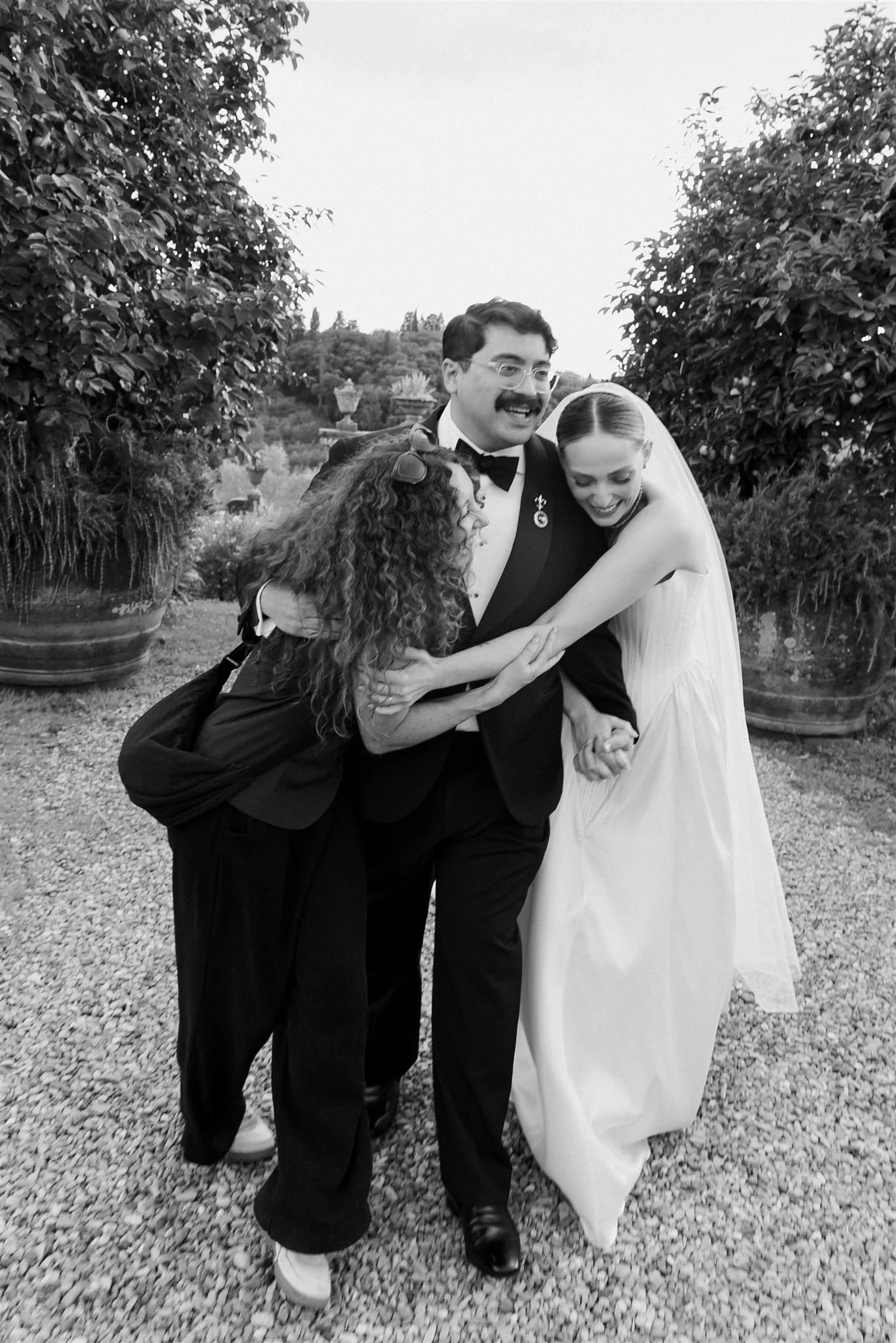 Rebecca Marie Weddings planner hugging the bride and groom at a Garden Wedding Ceremony on a wedding day at Villa Medicea Di Lilliano in Tuscany, Italy.