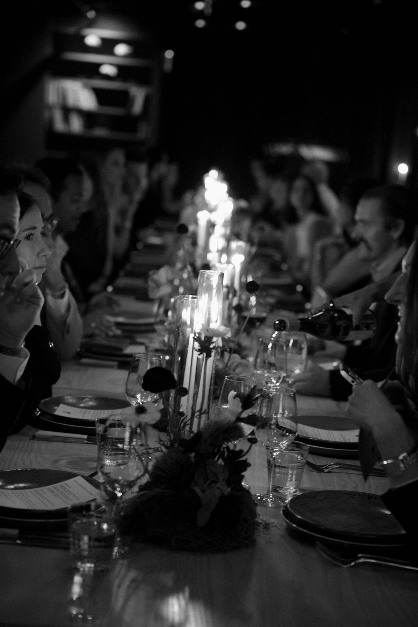 Wedding guests at a candlelit rehearsal dinner at Maxwells Trading Chicago wedding venue.