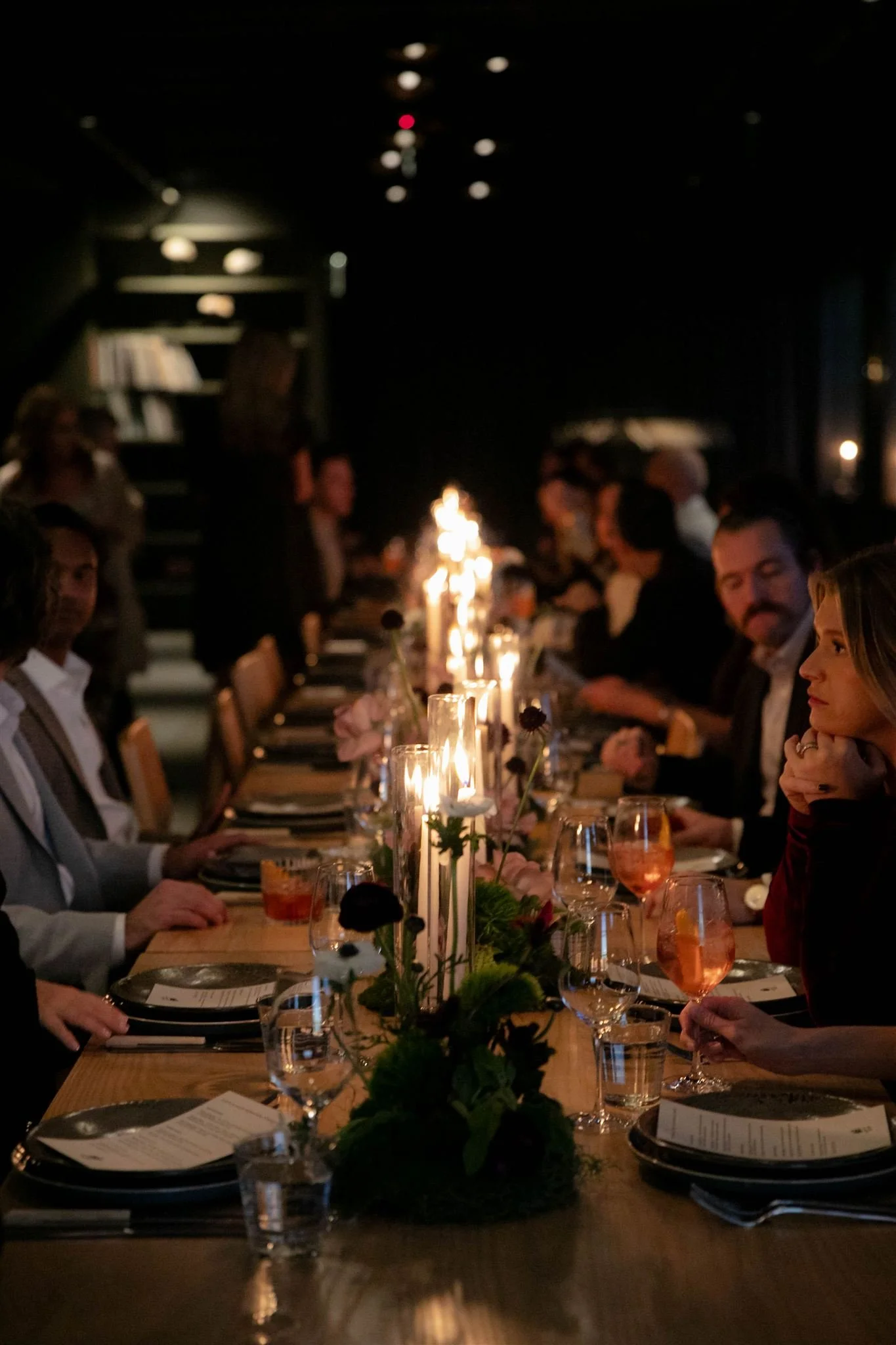 Wedding guests at a candlelit rehearsal dinner at Maxwells Trading Chicago wedding venue.