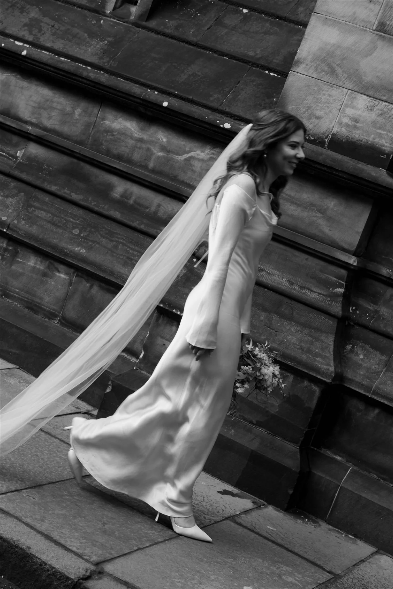 Wedding couple celebrating outside Edinburgh City Chambers, captured by an Edinburgh City Chambers wedding photographer in a cinematic style.