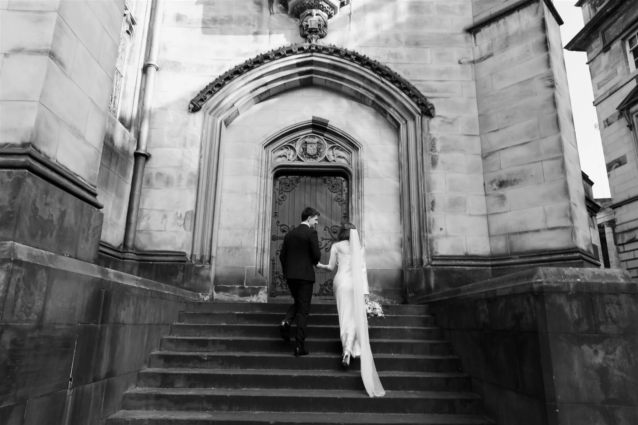 Wedding couple celebrating outside Edinburgh City Chambers, captured by an Edinburgh City Chambers wedding photographer in a candid style.