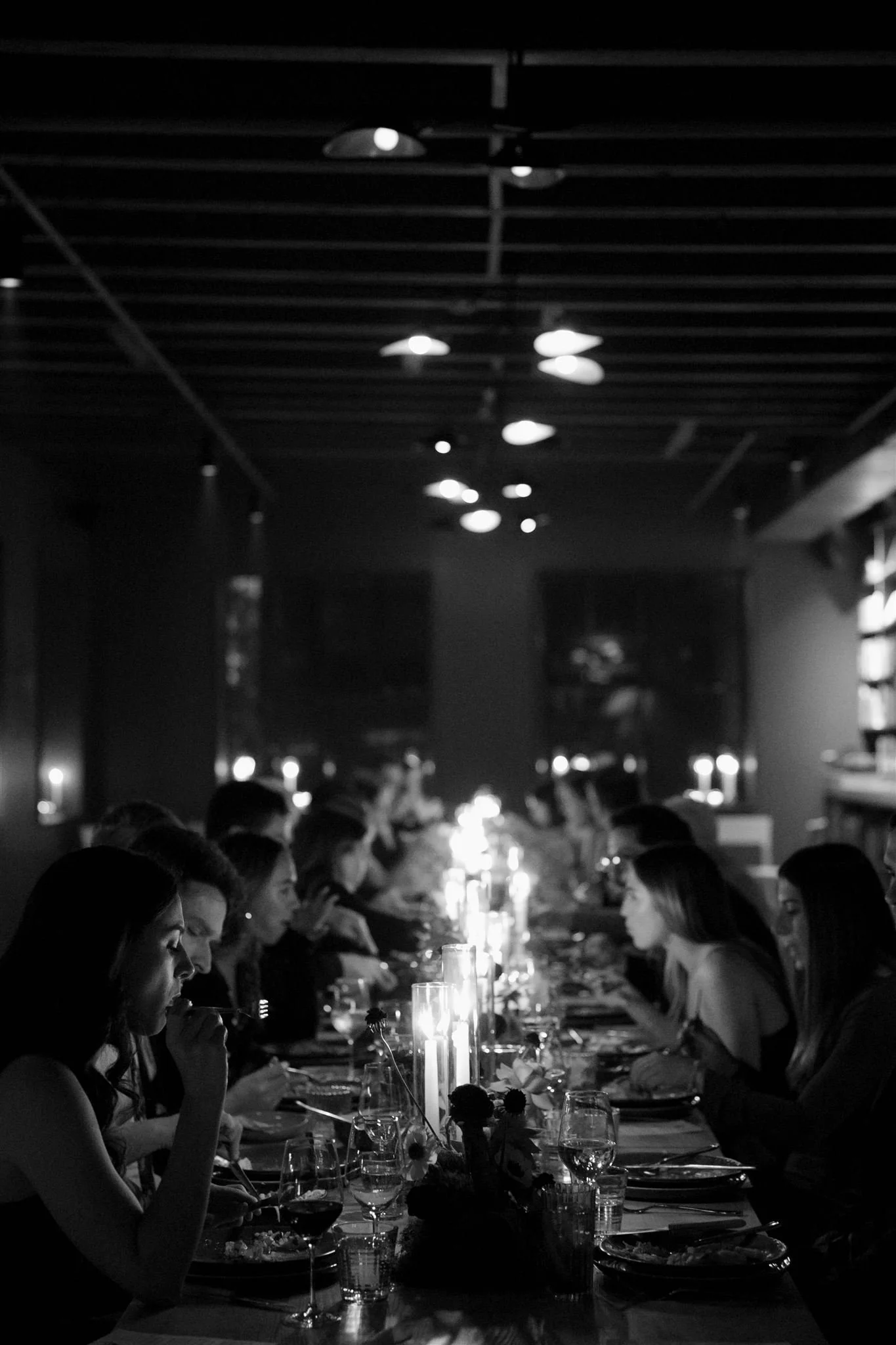 Wedding guests at a candlelit rehearsal dinner at Maxwells Trading Chicago wedding venue.