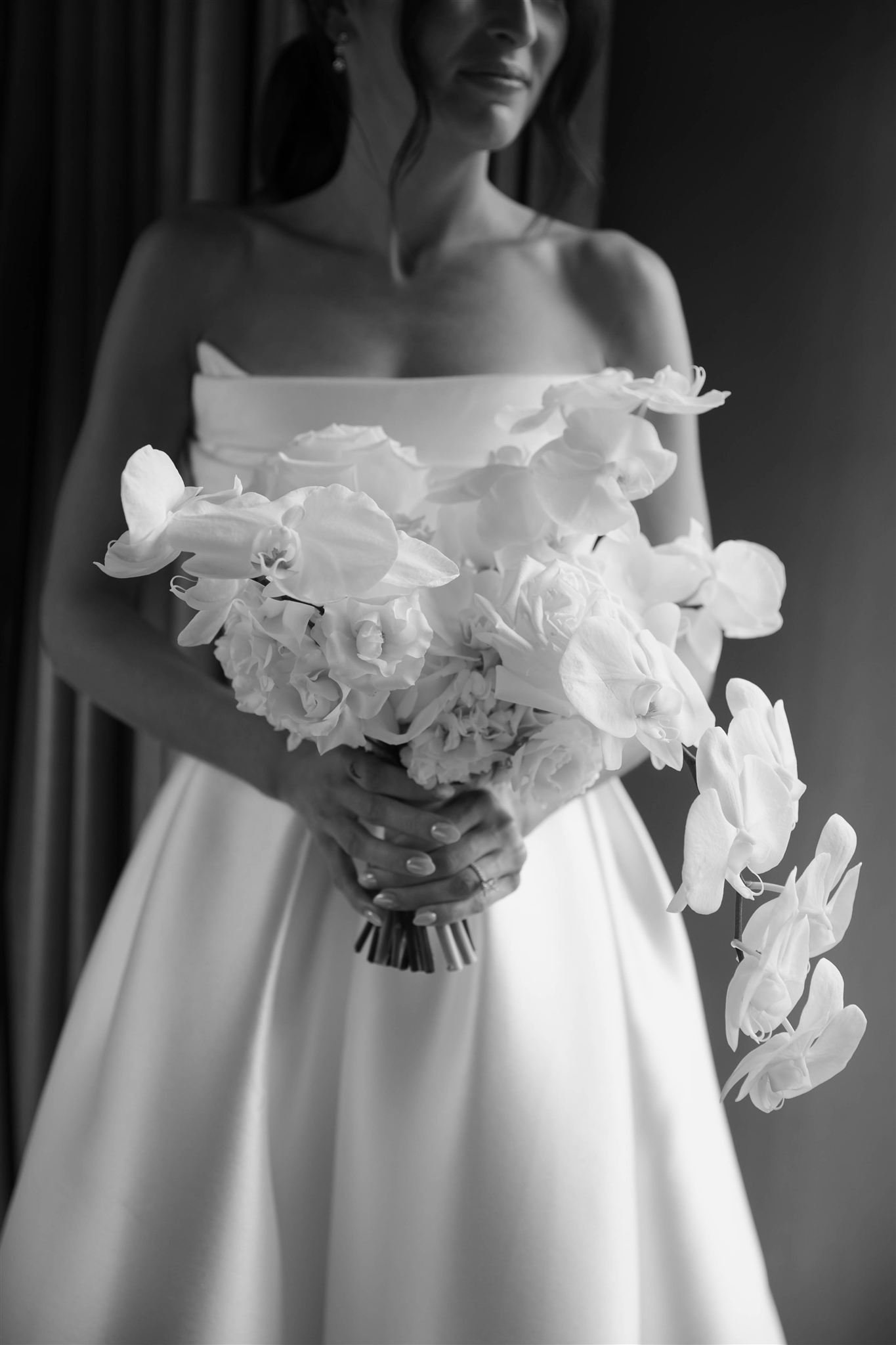 Bride and bouquet in Nobu Hotel suite overlooking downtown Chicago skyline on her wedding day.