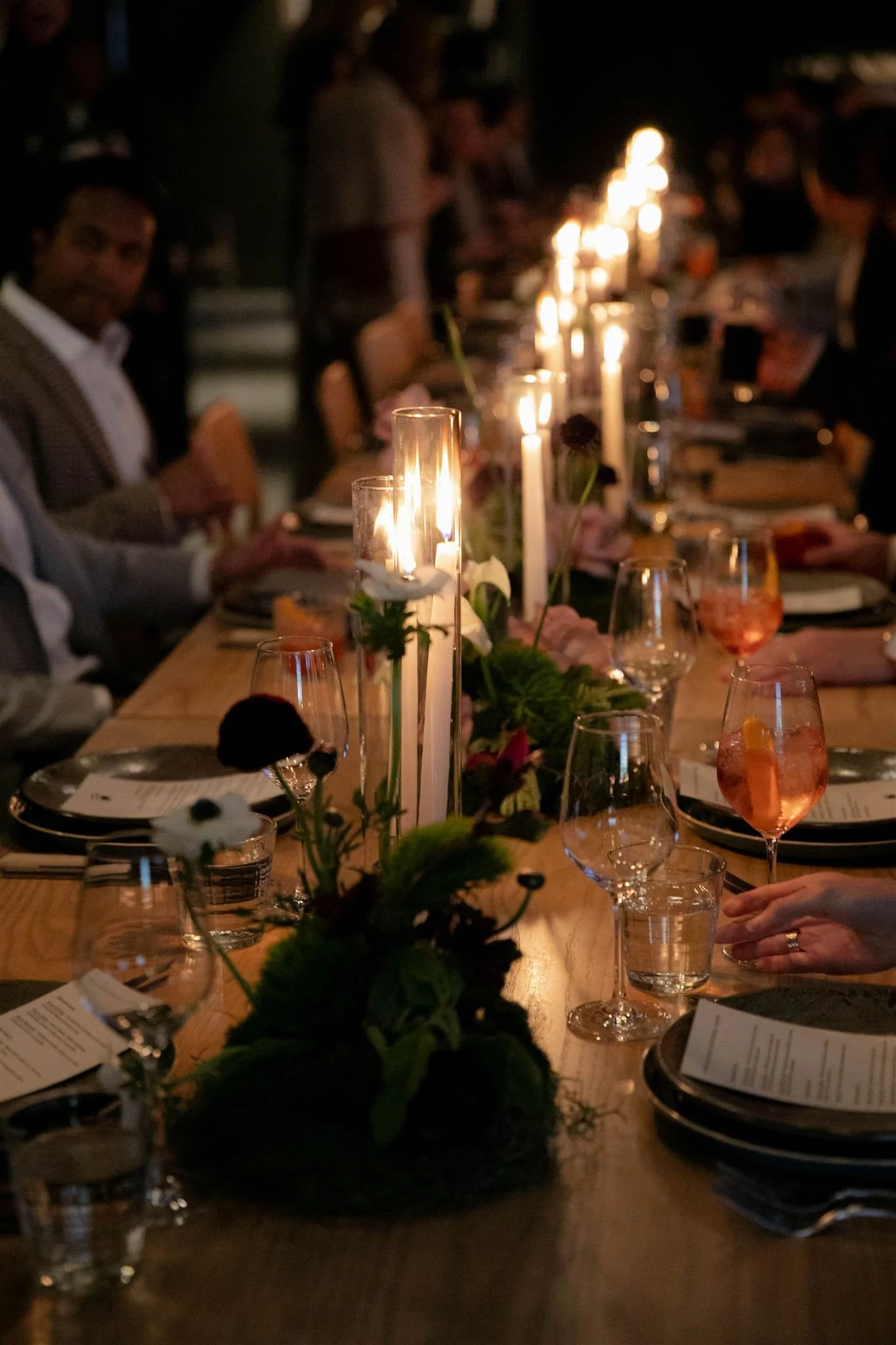Wedding guests at a candlelit rehearsal dinner at Maxwells Trading Chicago wedding venue.