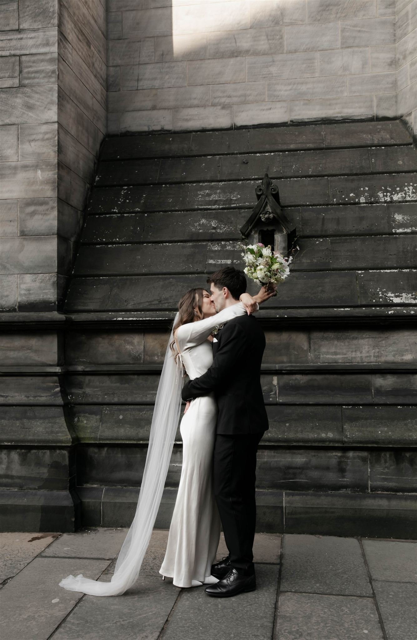 Wedding couple celebrating outside Edinburgh City Chambers, captured by an Edinburgh City Chambers wedding photographer in a relaxed style.