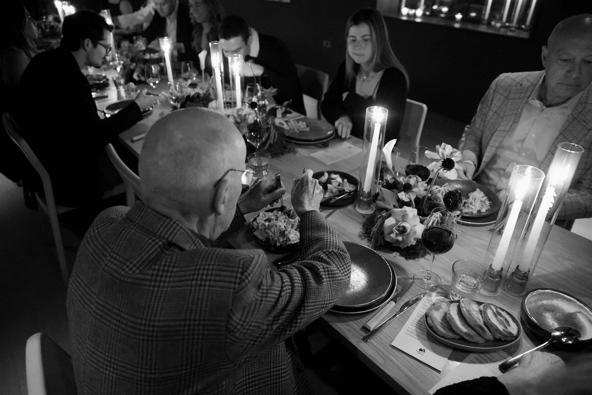 Wedding guests at a candlelit rehearsal dinner at Maxwells Trading Chicago wedding venue.