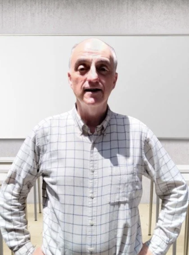 A man with curly black hair and a beard, wearing a white shirt, smiling and giving a thumbs-up, standing next to a woman holding a document.