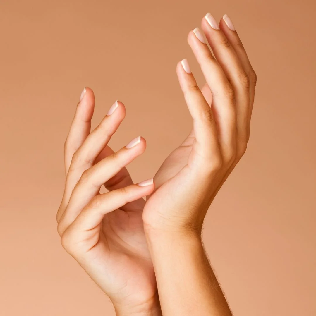 Close-up of two hands with intertwined fingers against a neutral background.