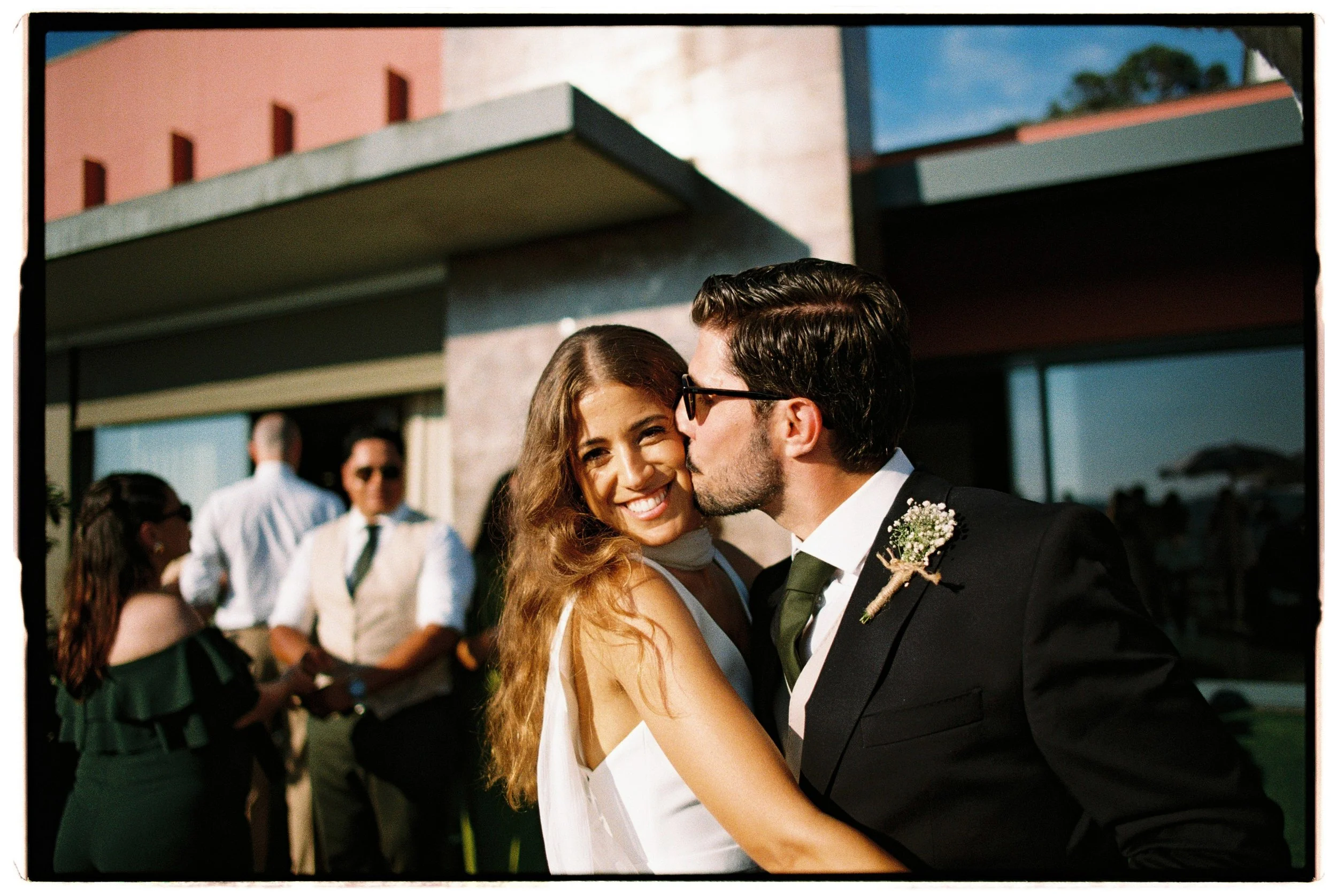 A bride and groom sharing a dance at their outdoor wedding reception, with guests in the background.