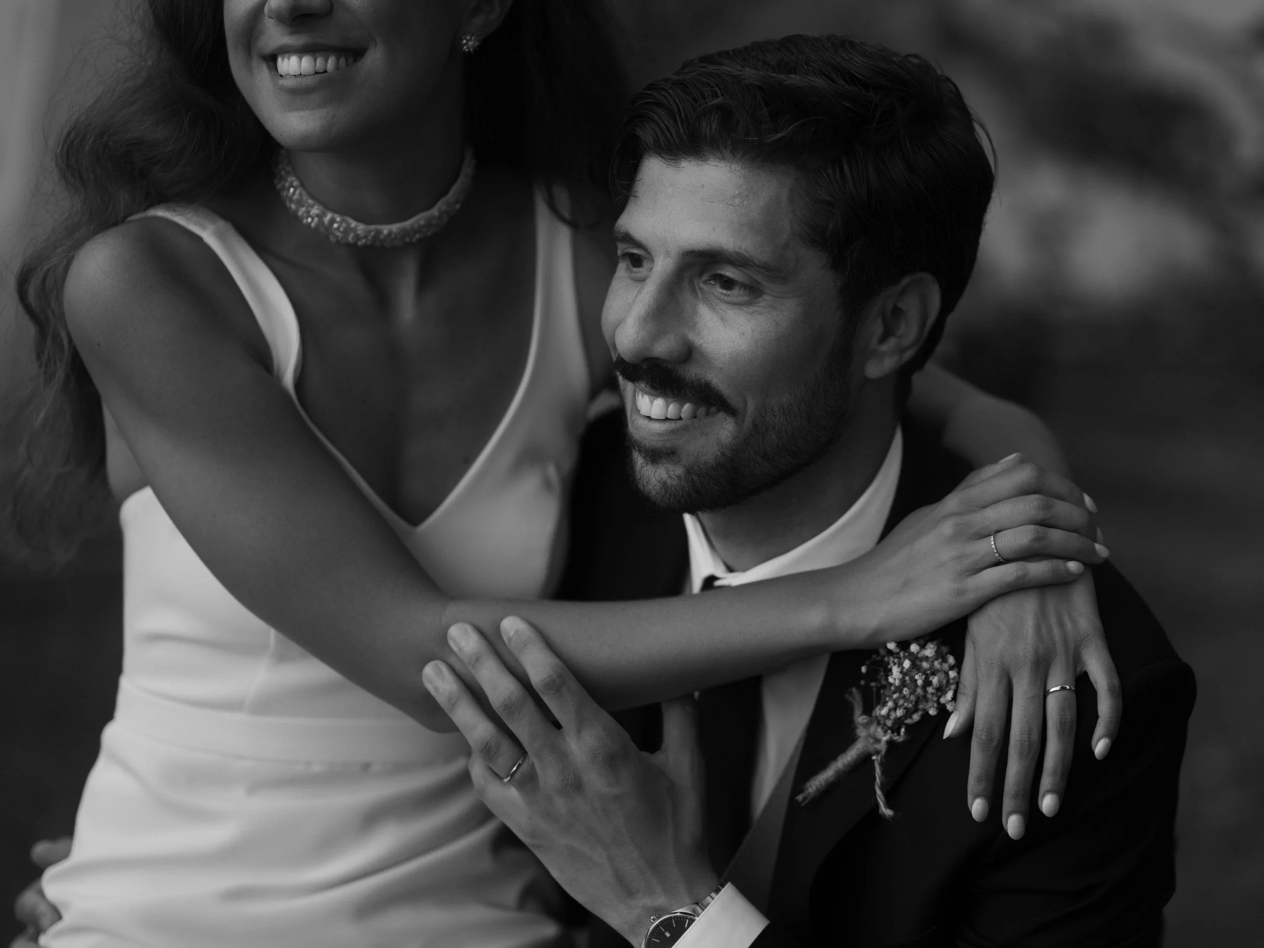 A black-and-white photograph of a smiling woman and man embracing each other.