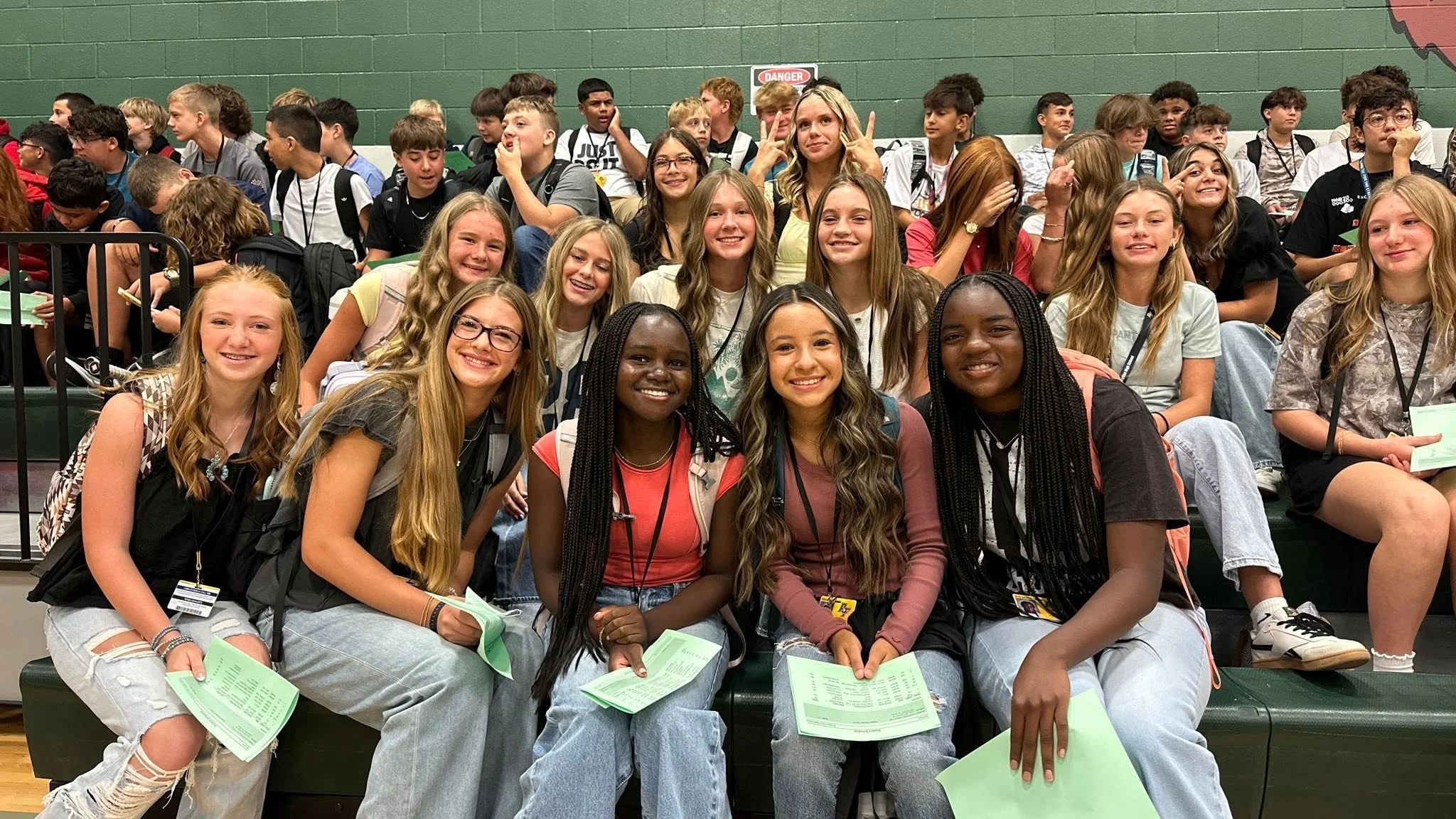Group of young students sitting on bleachers at school event