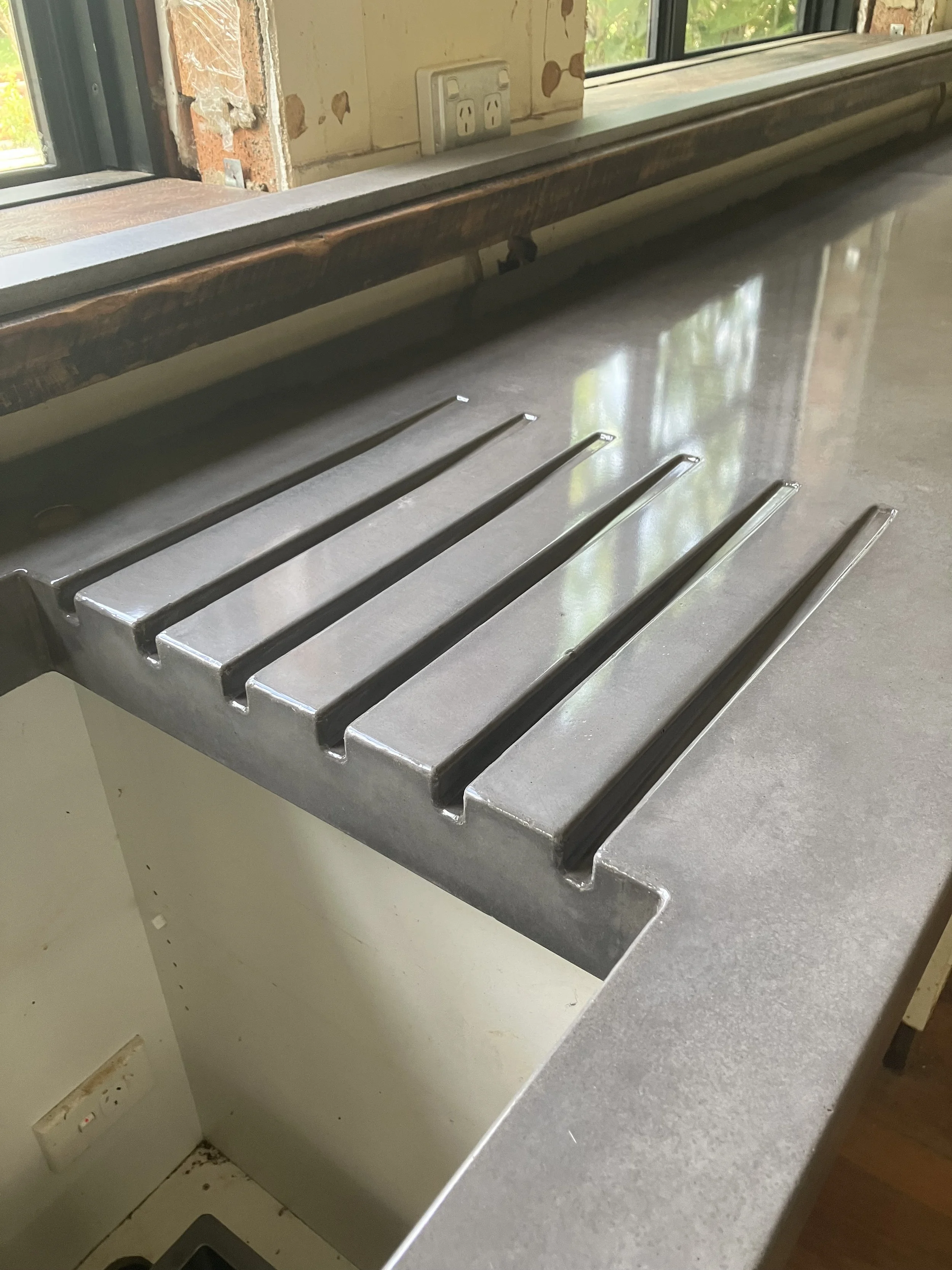 Concrete benchtop with integrated drainage grooves for practical kitchen use Melbourne

